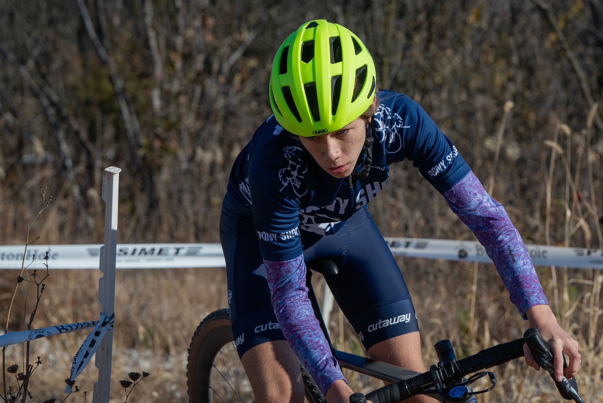 A person wearing a yellow helmet is riding a bike.