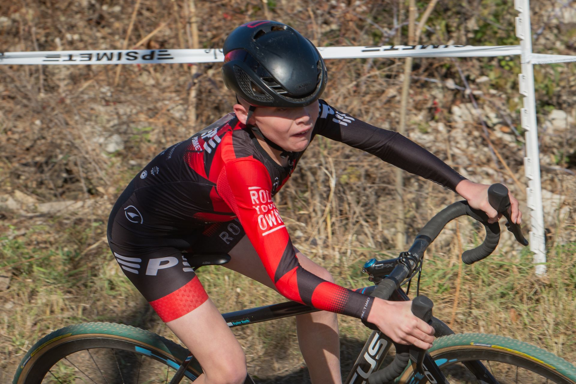 A young boy is riding a bicycle on a dirt road.