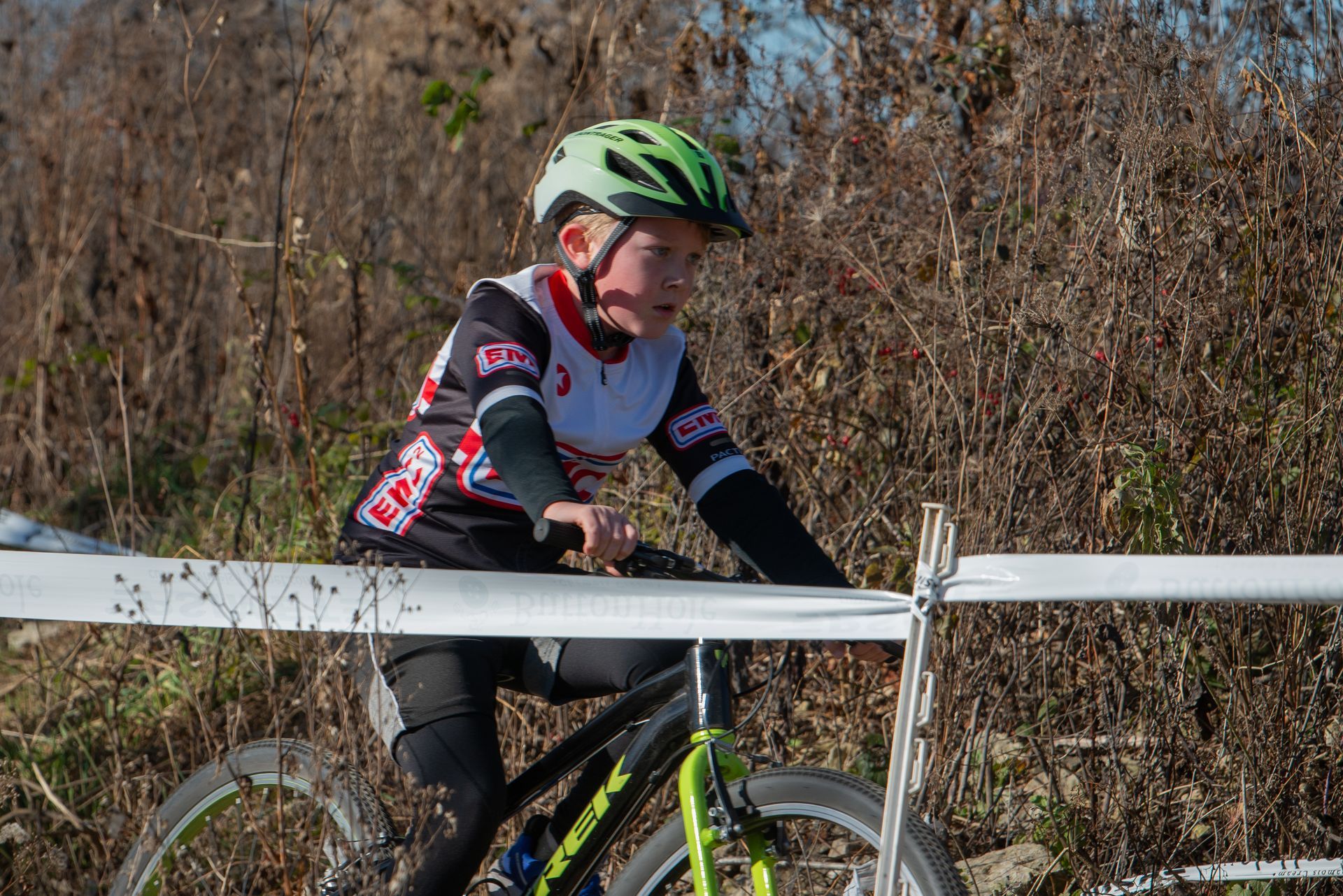 A young boy wearing a helmet is riding a bike.