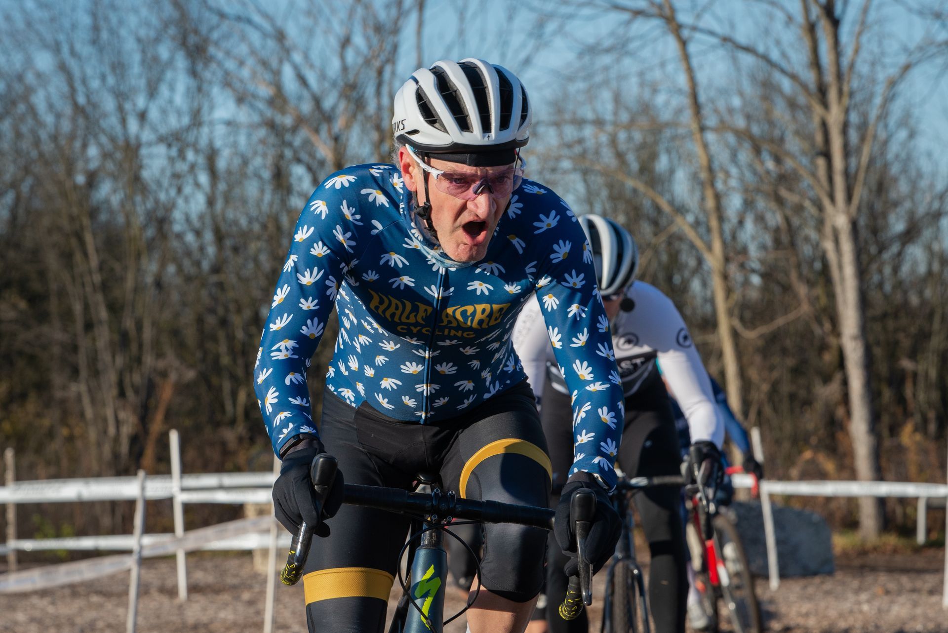 A group of men are riding bicycles on a dirt road.