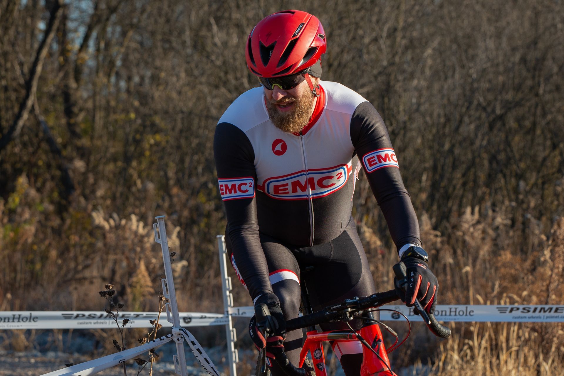 A man wearing a helmet and sunglasses is riding a bike.