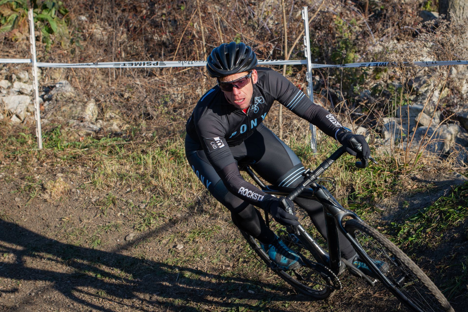 A man is riding a bike on a dirt road.