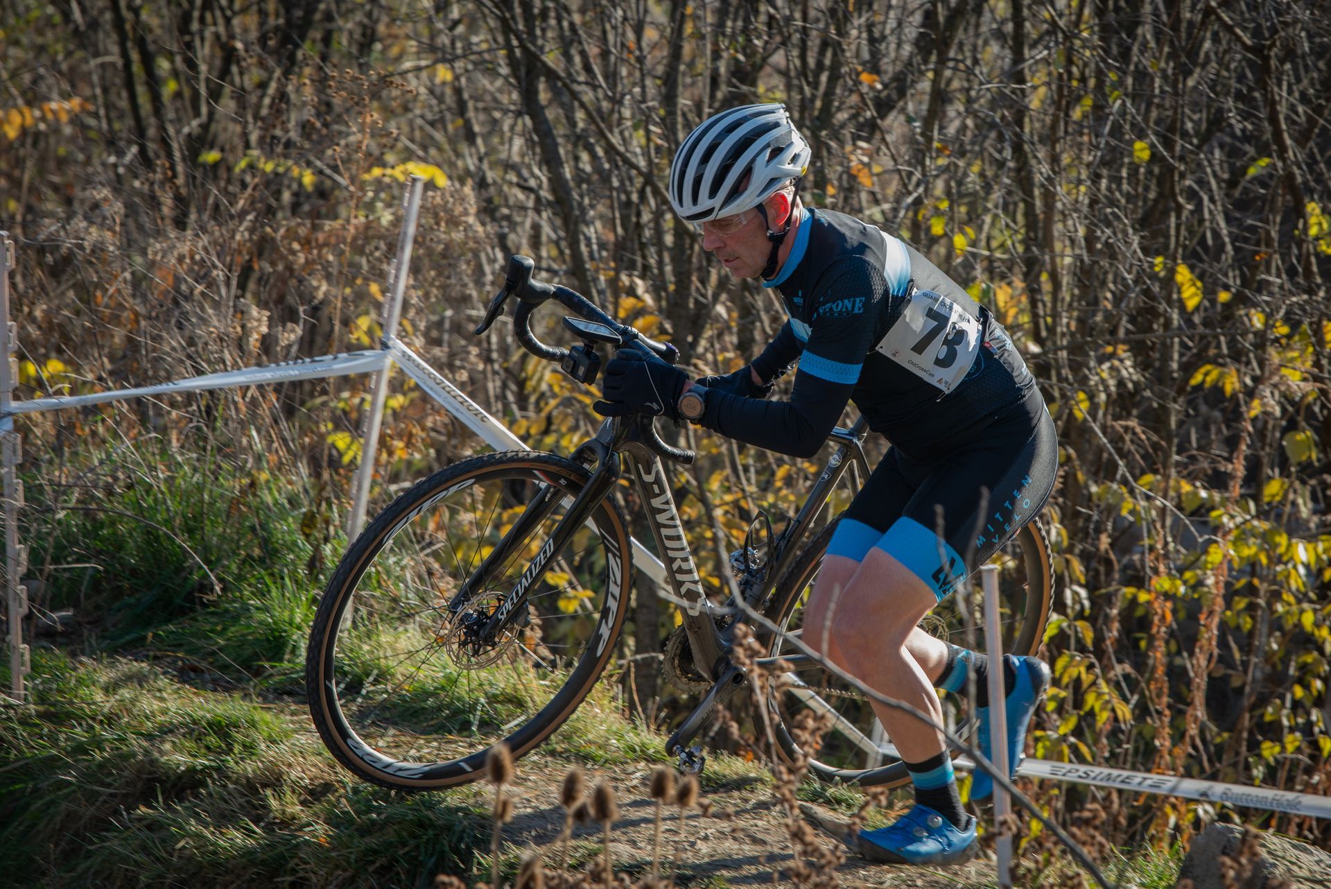 A man is riding a bicycle on a dirt road.