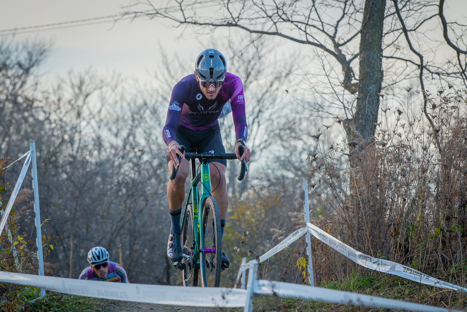 A man is riding a bike down a dirt road.