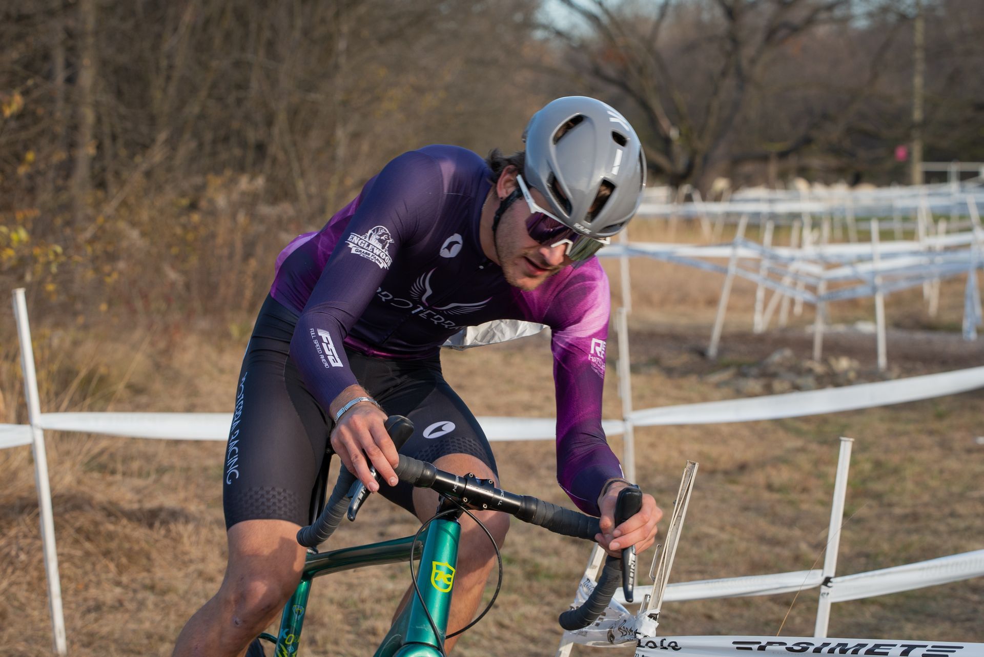 A man wearing a helmet and sunglasses is riding a bicycle.