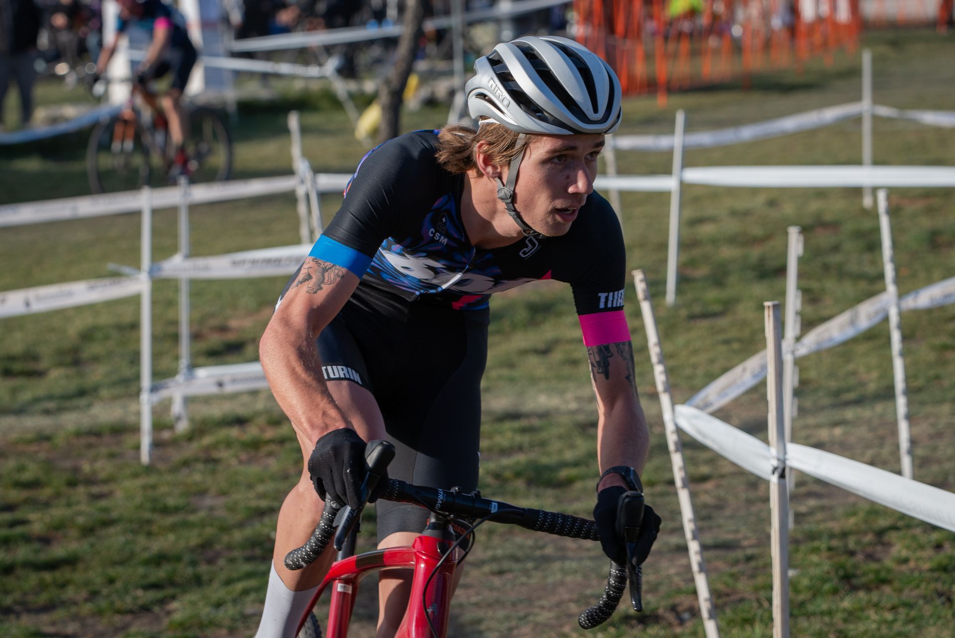 A man is riding a bike on a dirt road.
