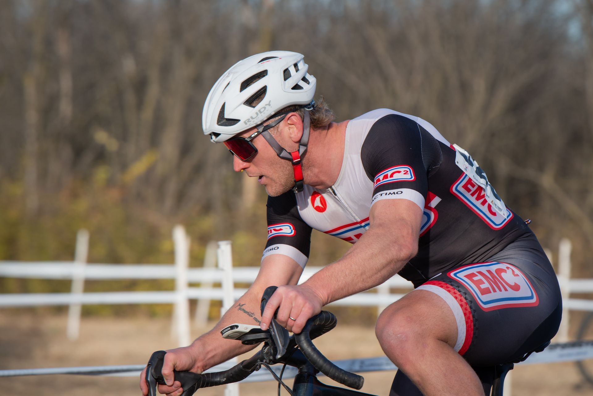 A man wearing a helmet and sunglasses is riding a bike.