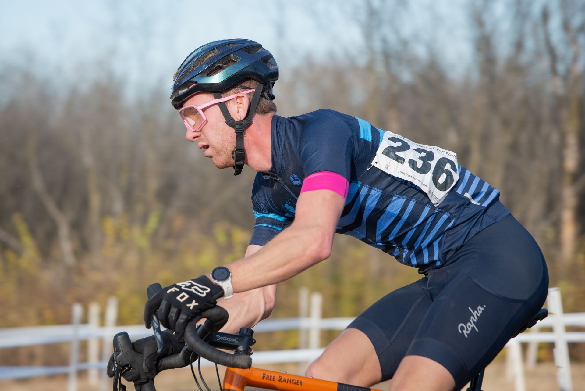 A man wearing a helmet and sunglasses is riding a bike.