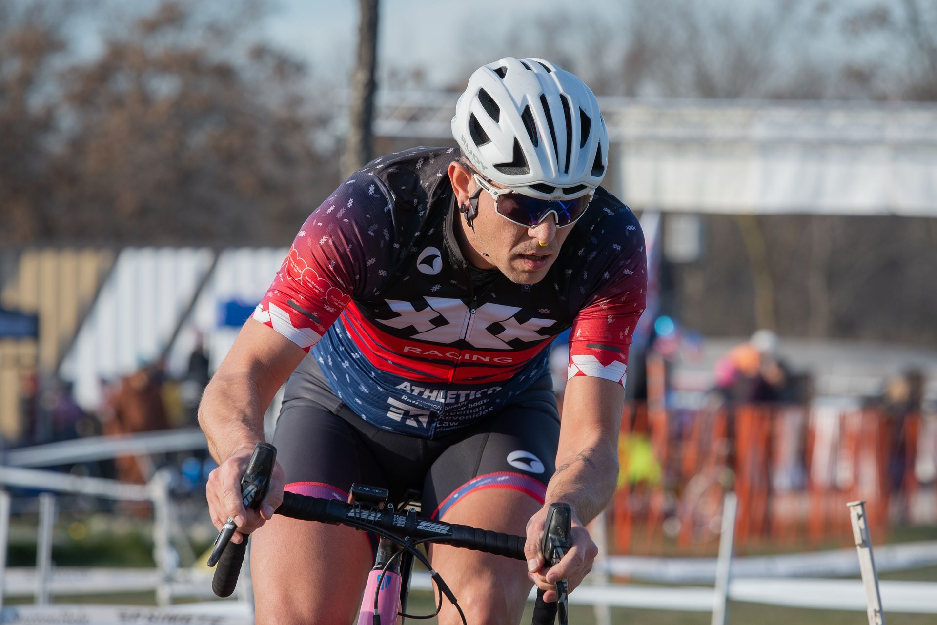A man wearing a helmet and sunglasses is riding a bike.