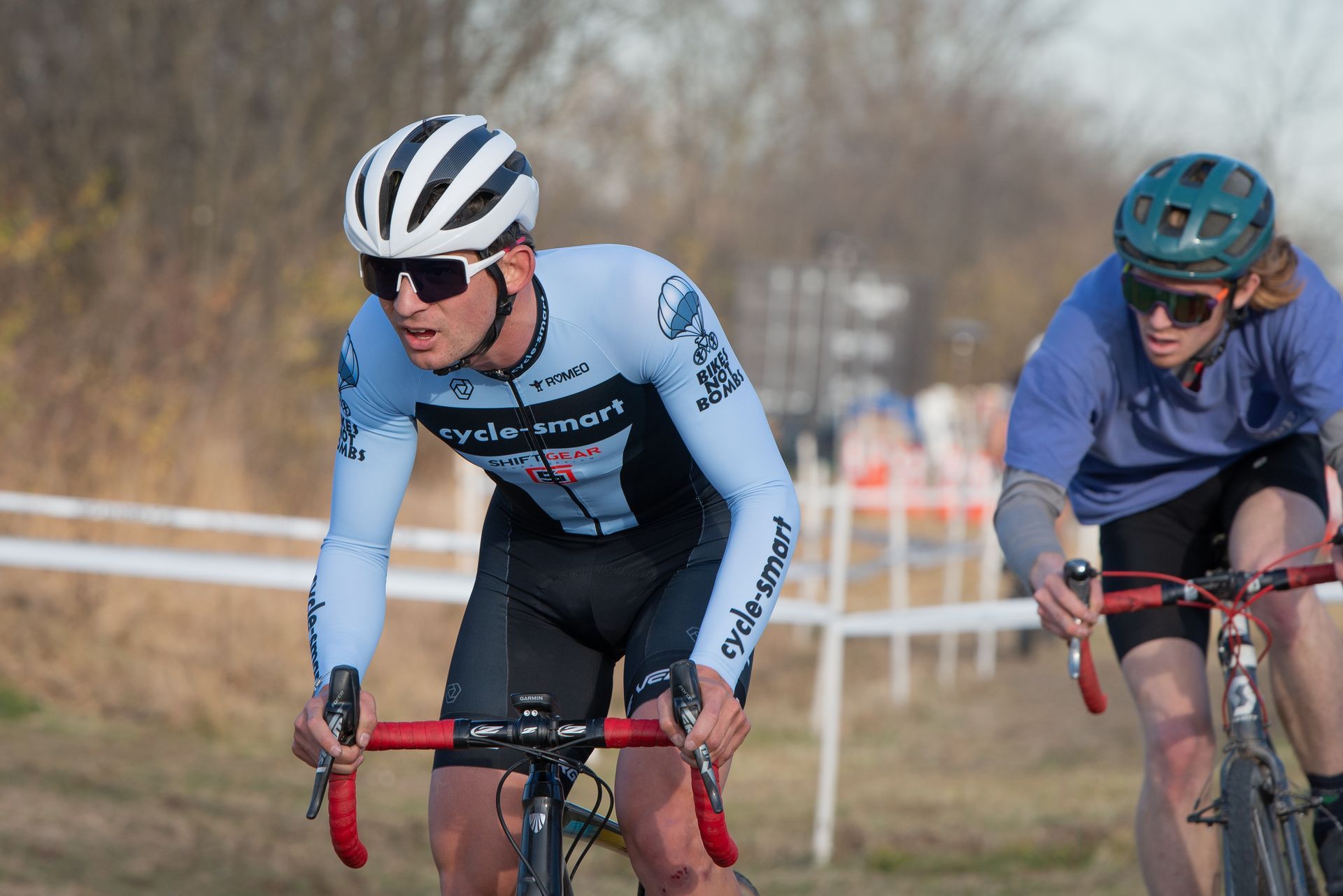 A man and a woman are riding bicycles on a dirt road.