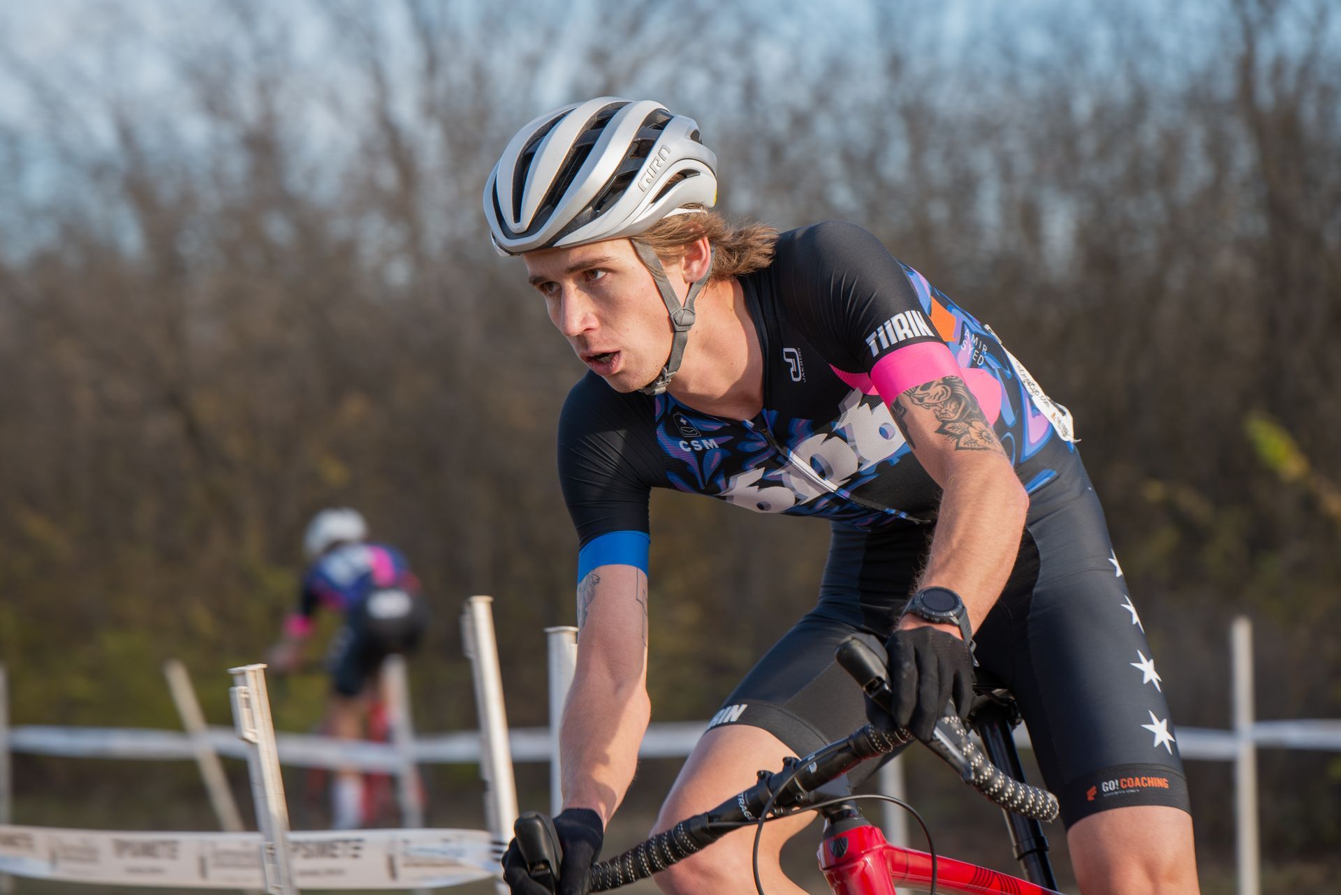 A man wearing a helmet is riding a bike in a race.