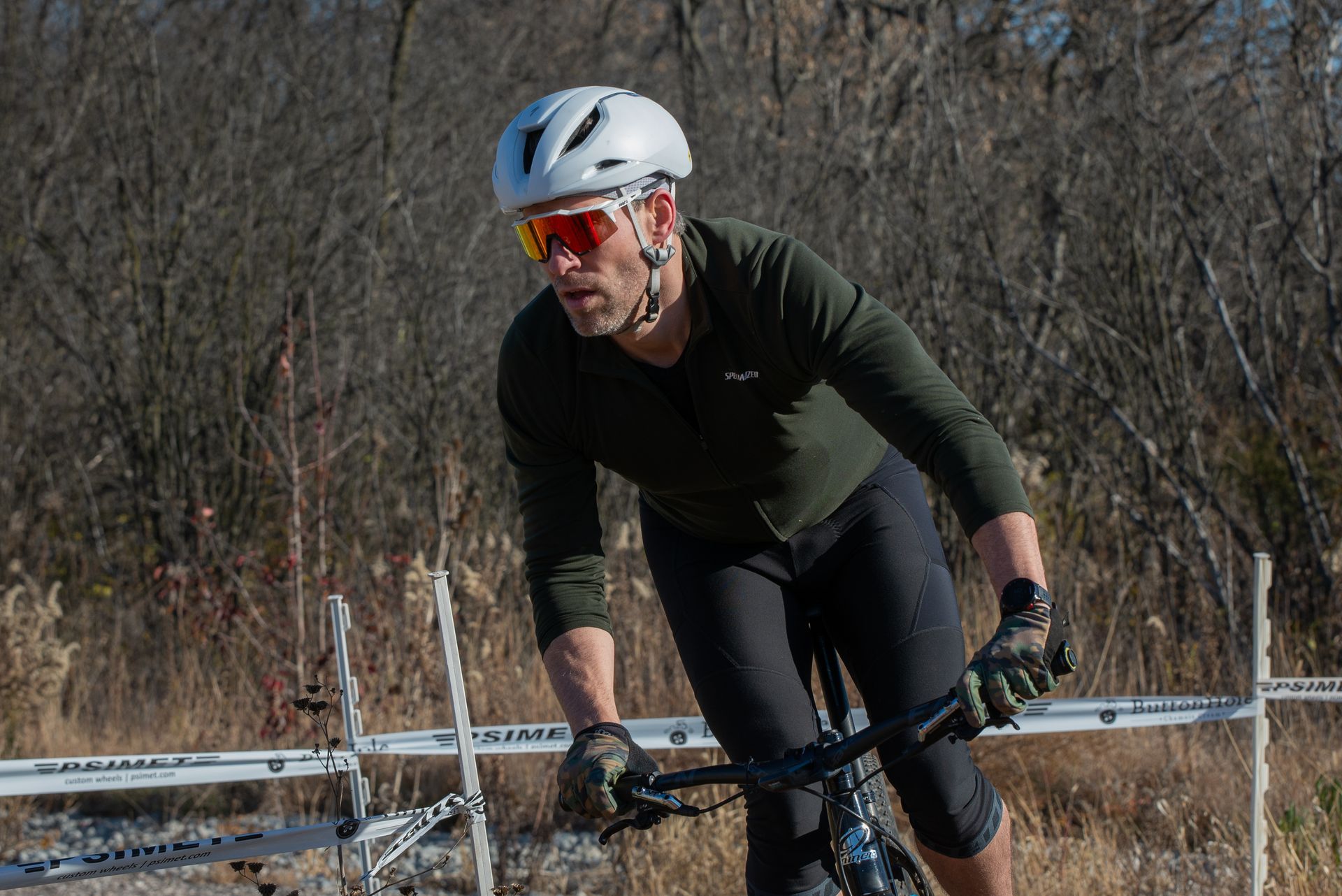 A man wearing a helmet and sunglasses is riding a bike.