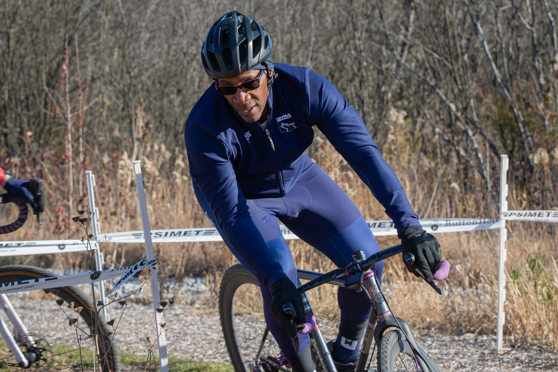 A man is riding a bike on a dirt road.