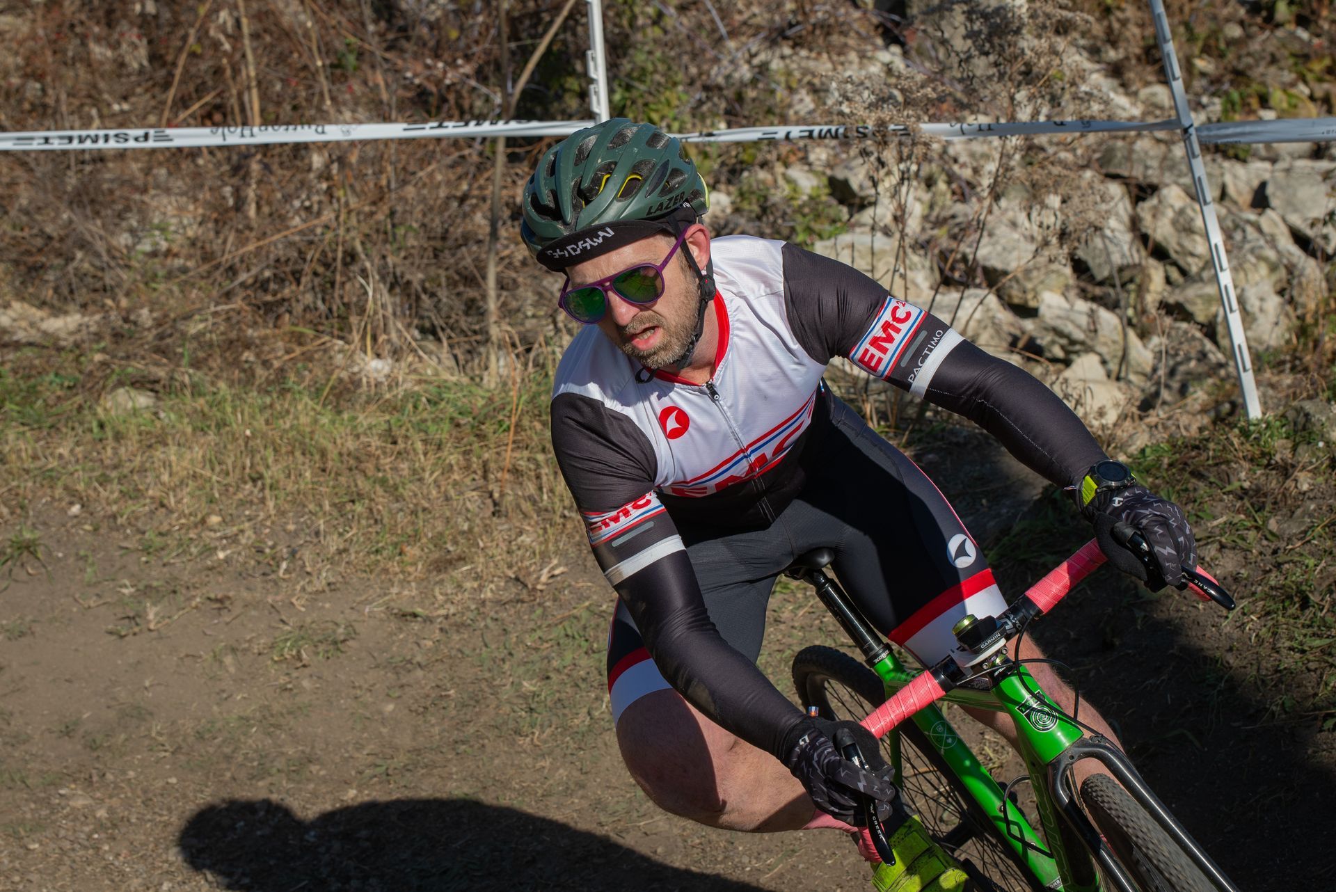 A man is riding a bike on a dirt road.