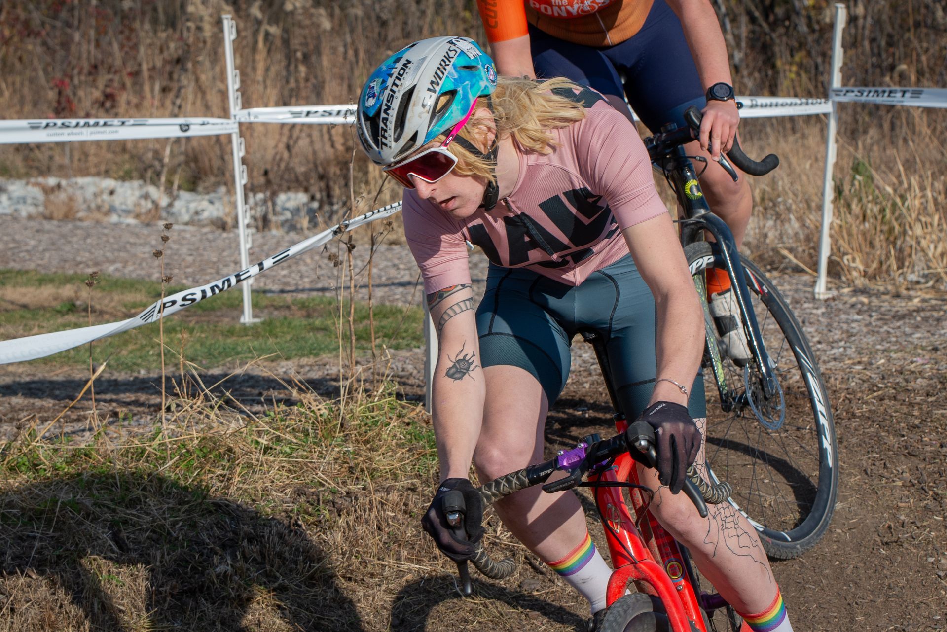 A man and a woman are riding bicycles on a dirt road.