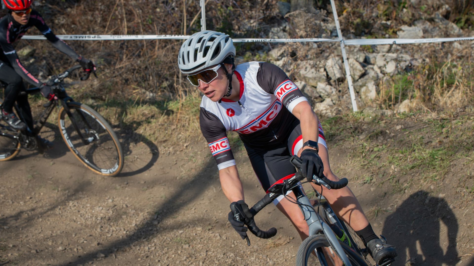 A man is riding a bike on a dirt road.