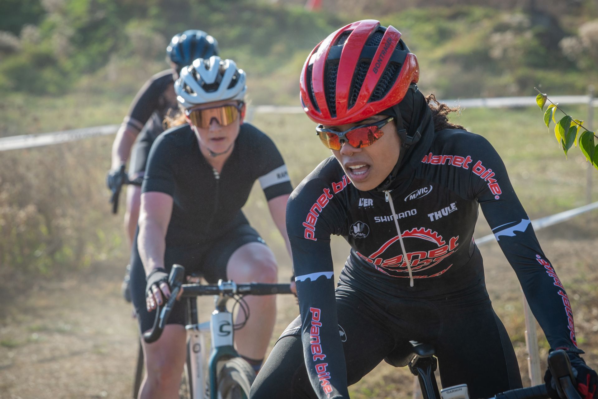 A group of women are riding bicycles on a dirt road.
