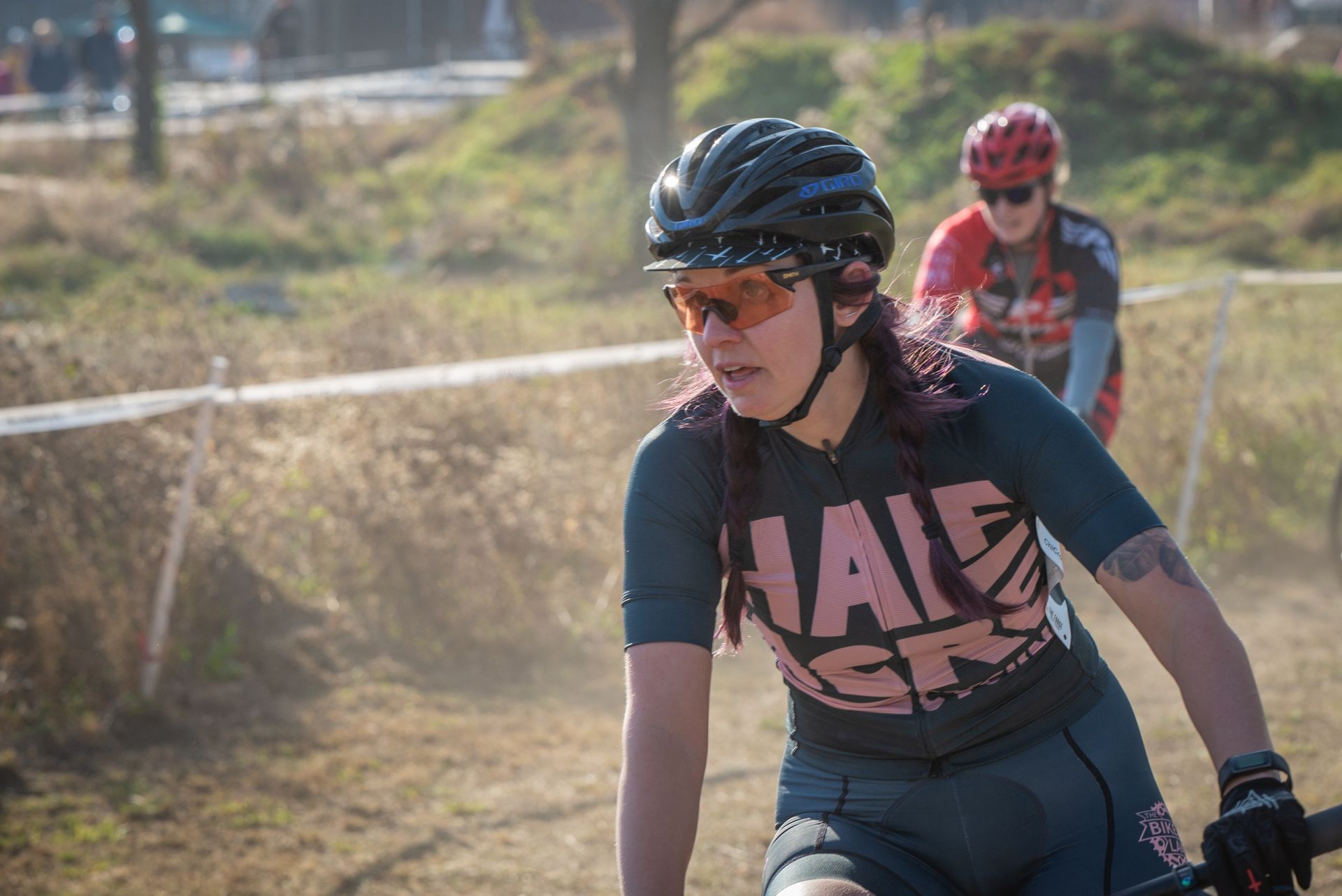 A woman is riding a bike on a dirt road.