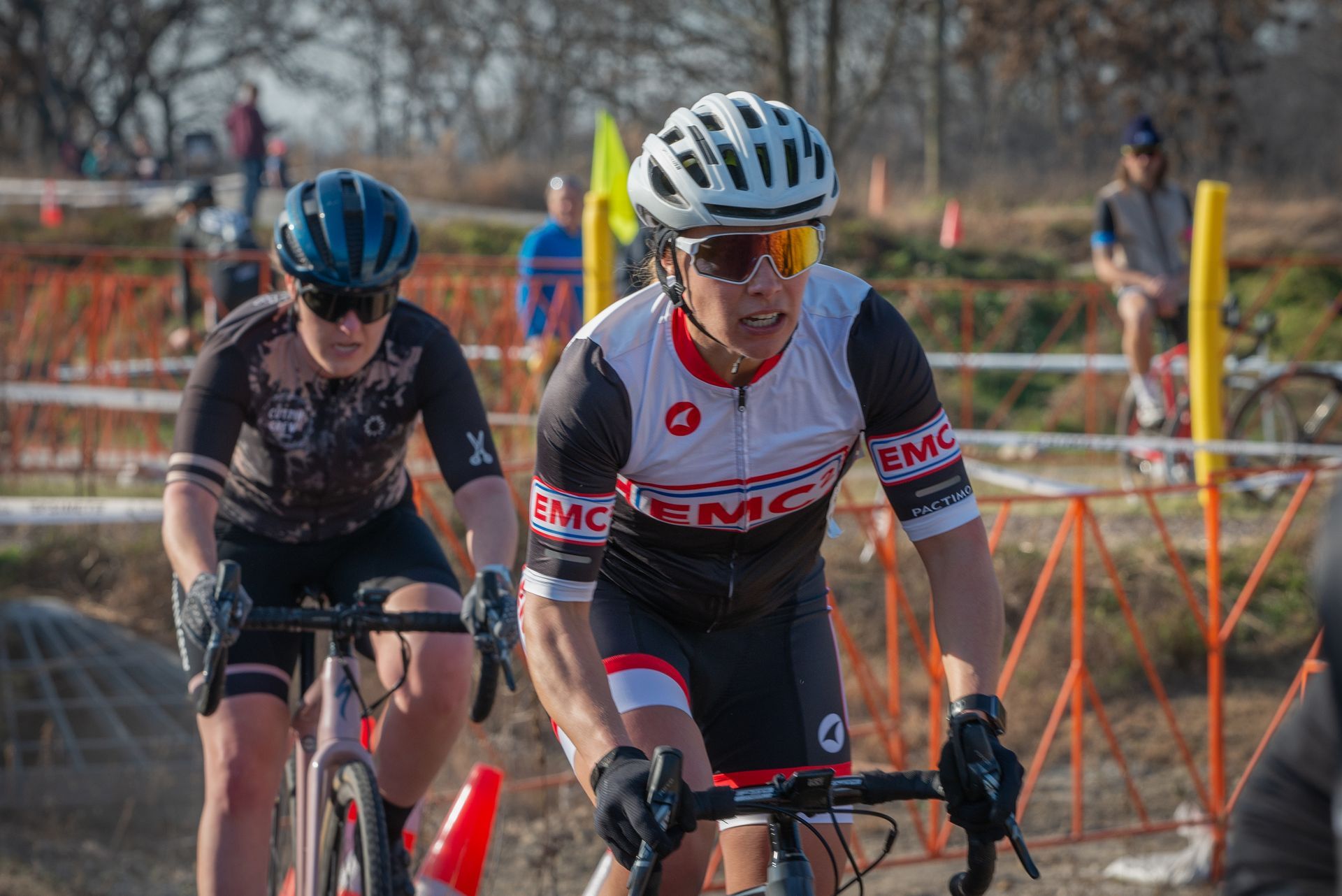 A man and a woman are riding bicycles on a dirt road.