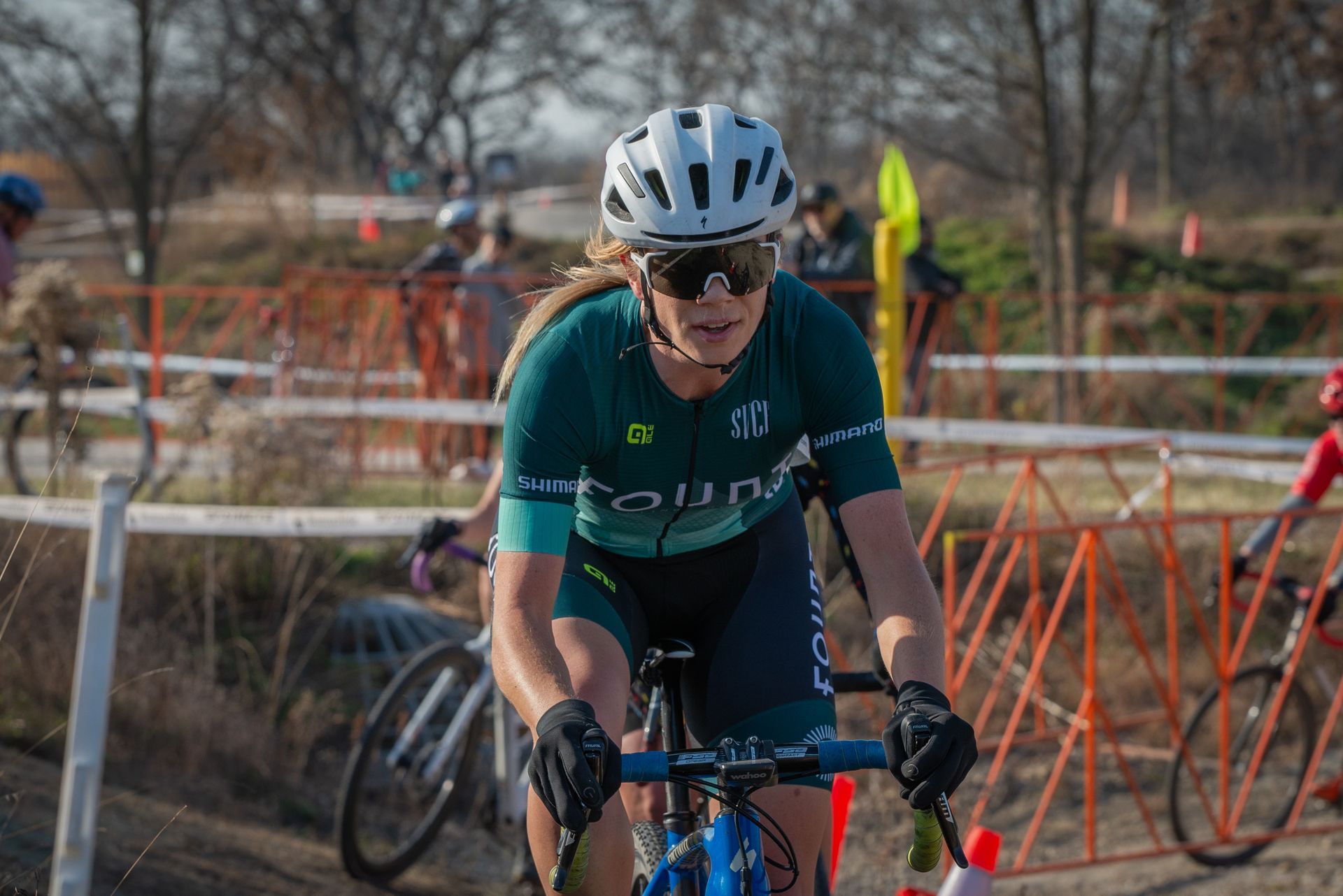 A woman is riding a bike on a dirt road.