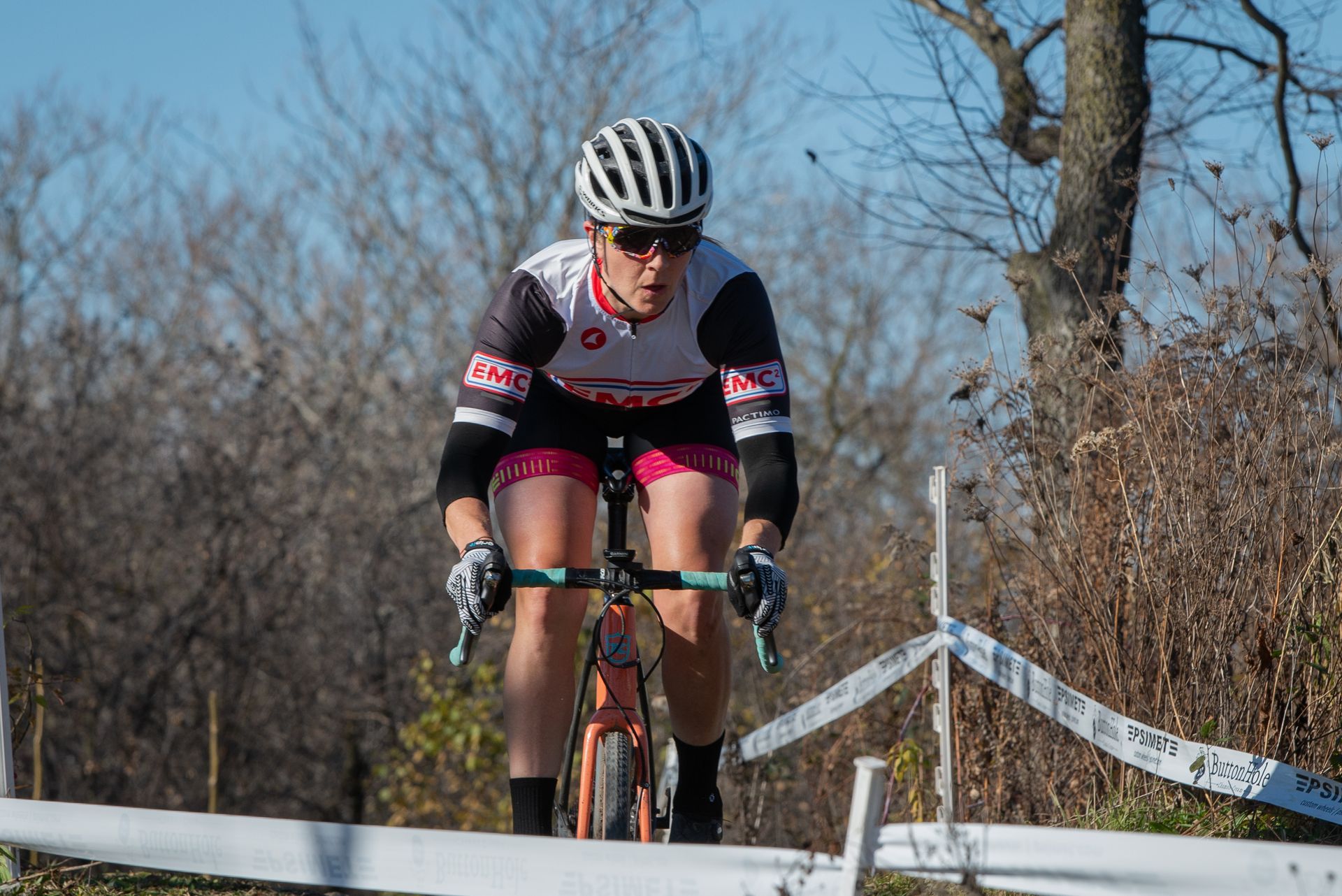 A woman is riding a bicycle on a dirt road.