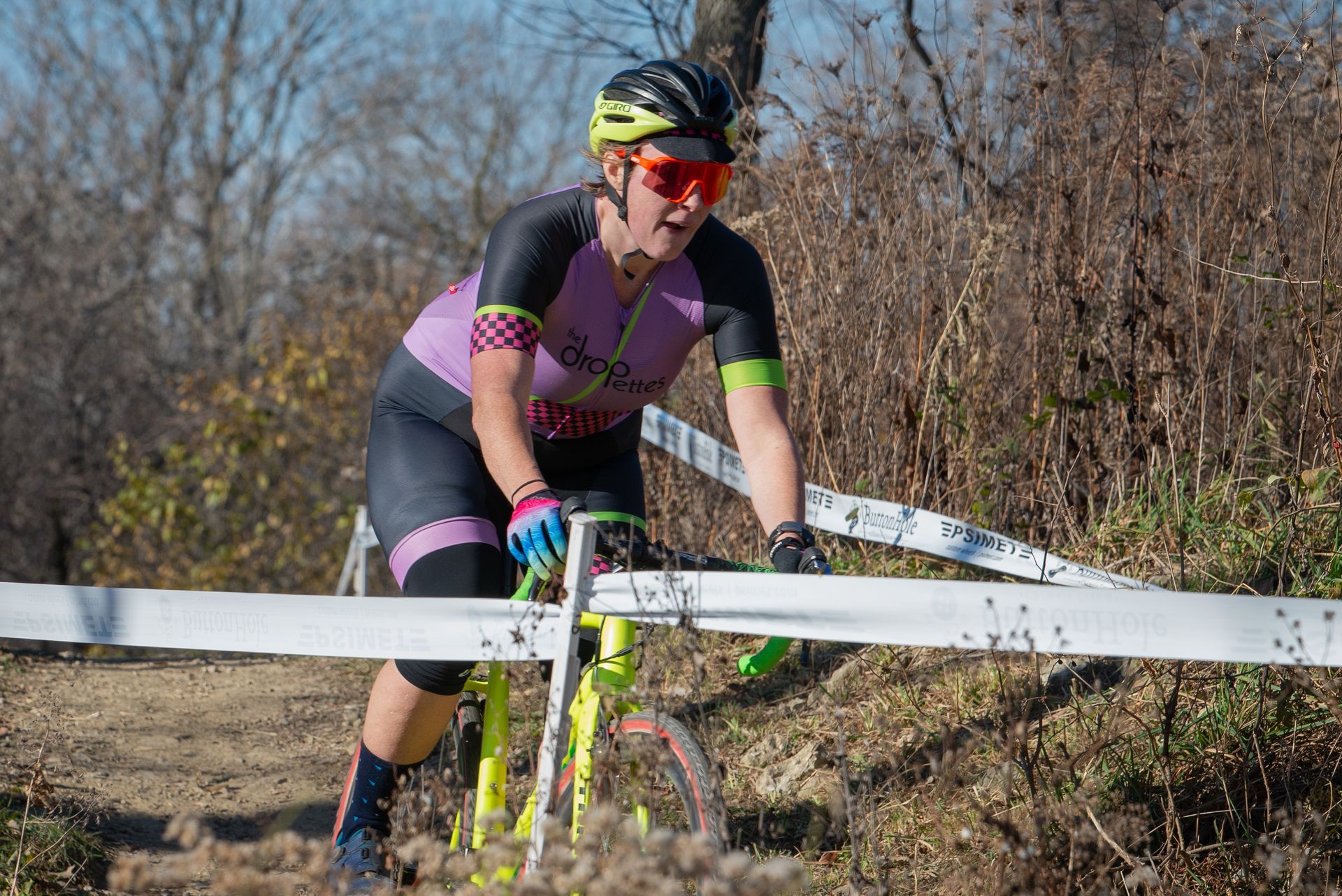 A woman is riding a bike on a dirt road.
