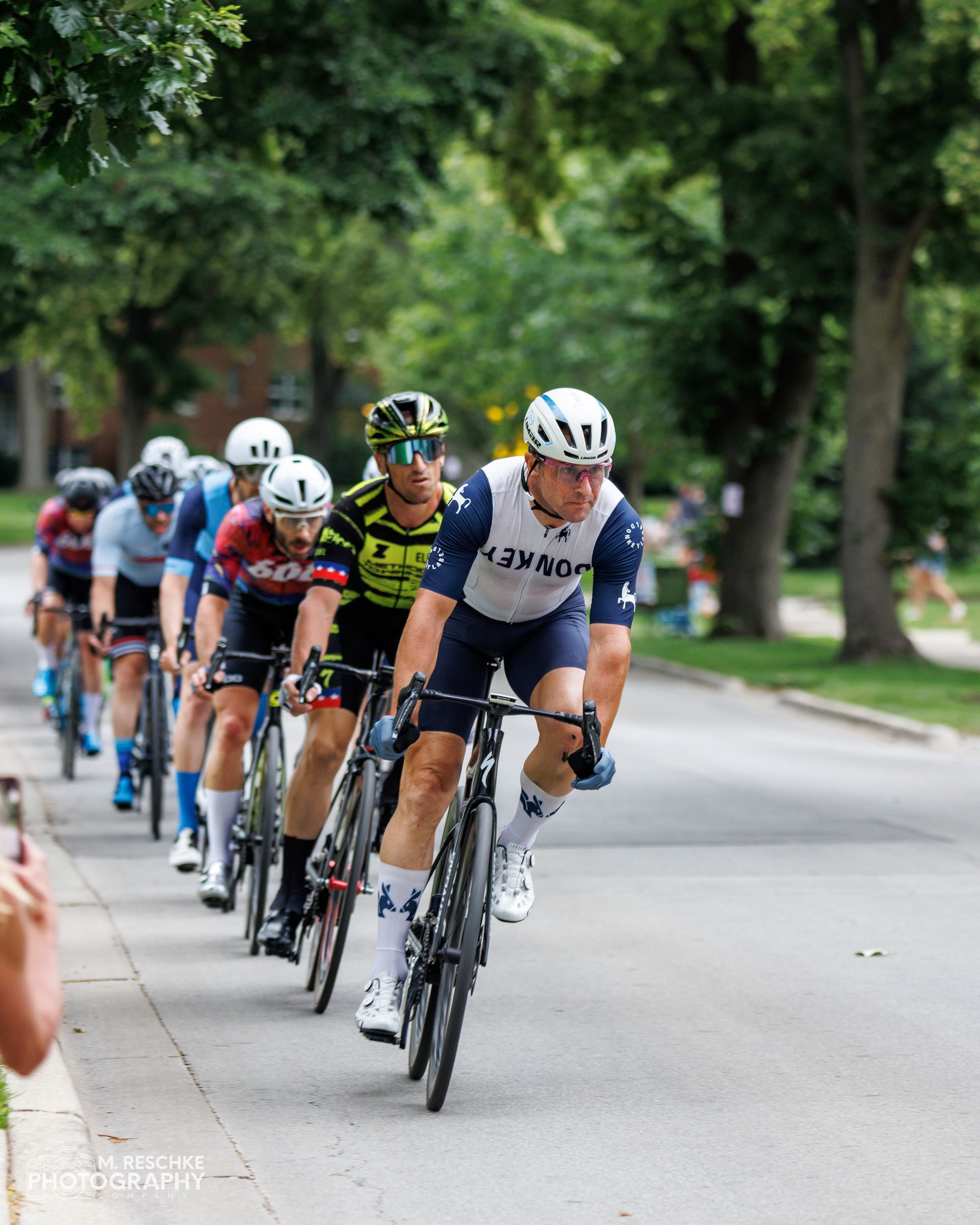 A group of cyclists are riding down a street.