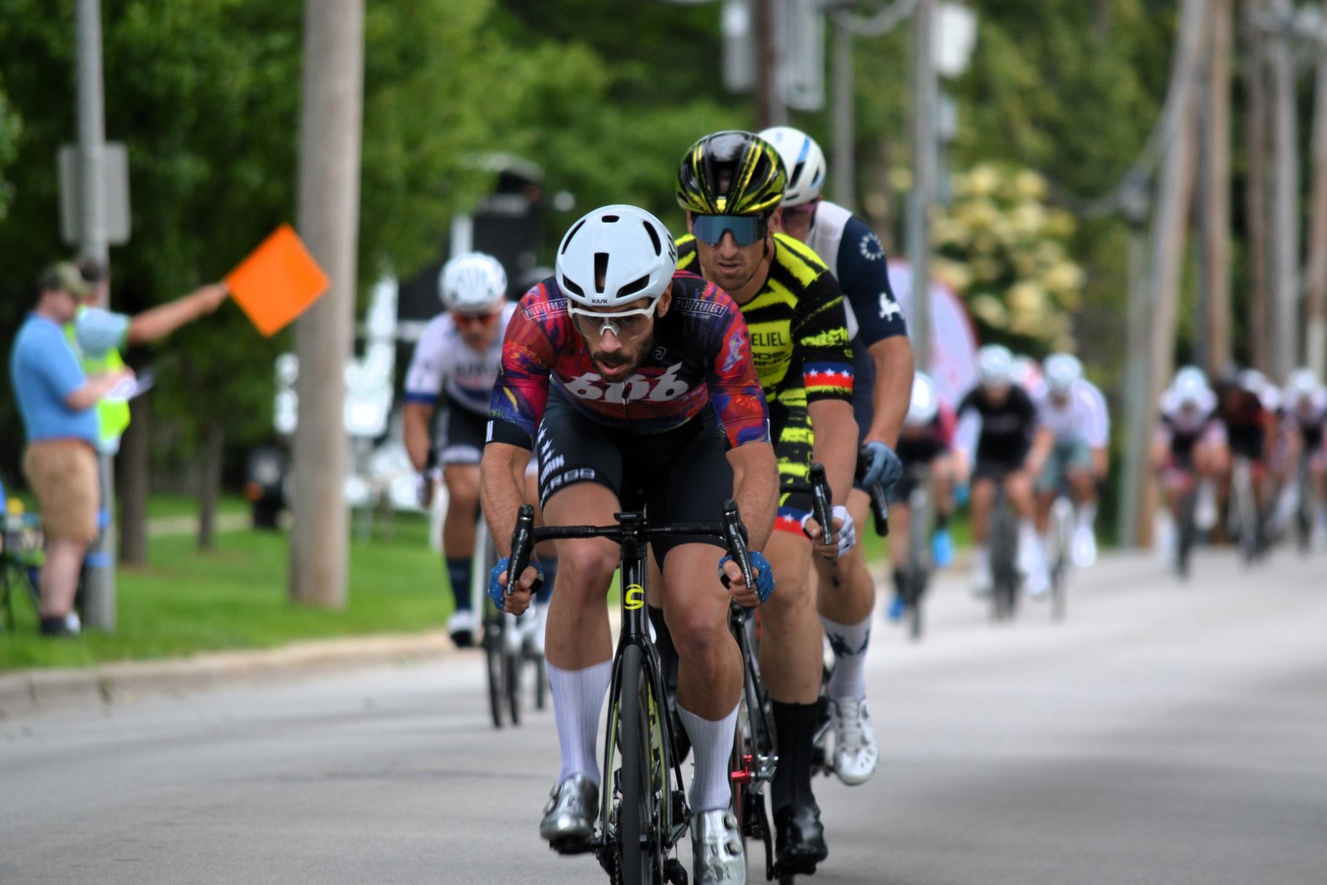 A group of people are riding bicycles down a street.