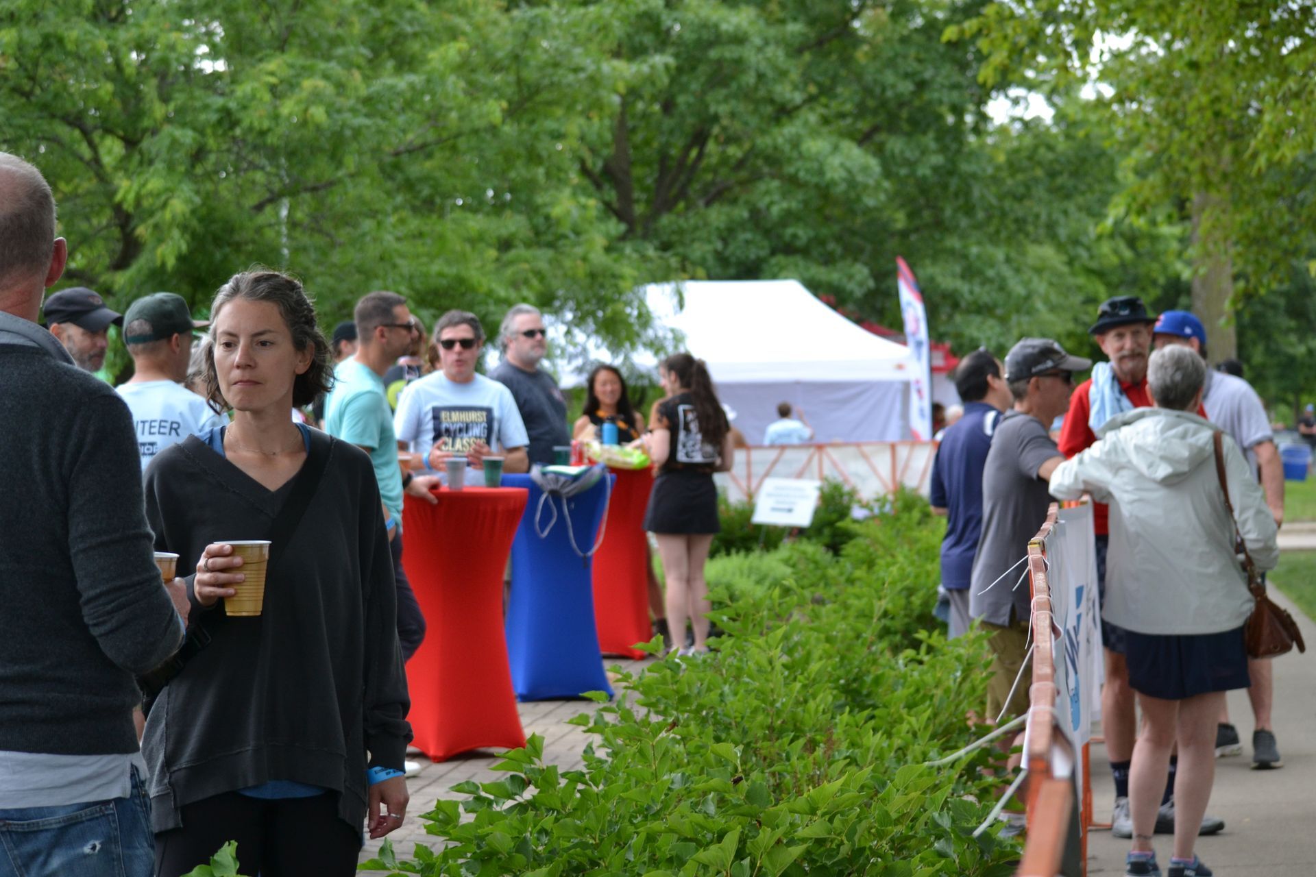 A group of people are walking down a sidewalk in a park.