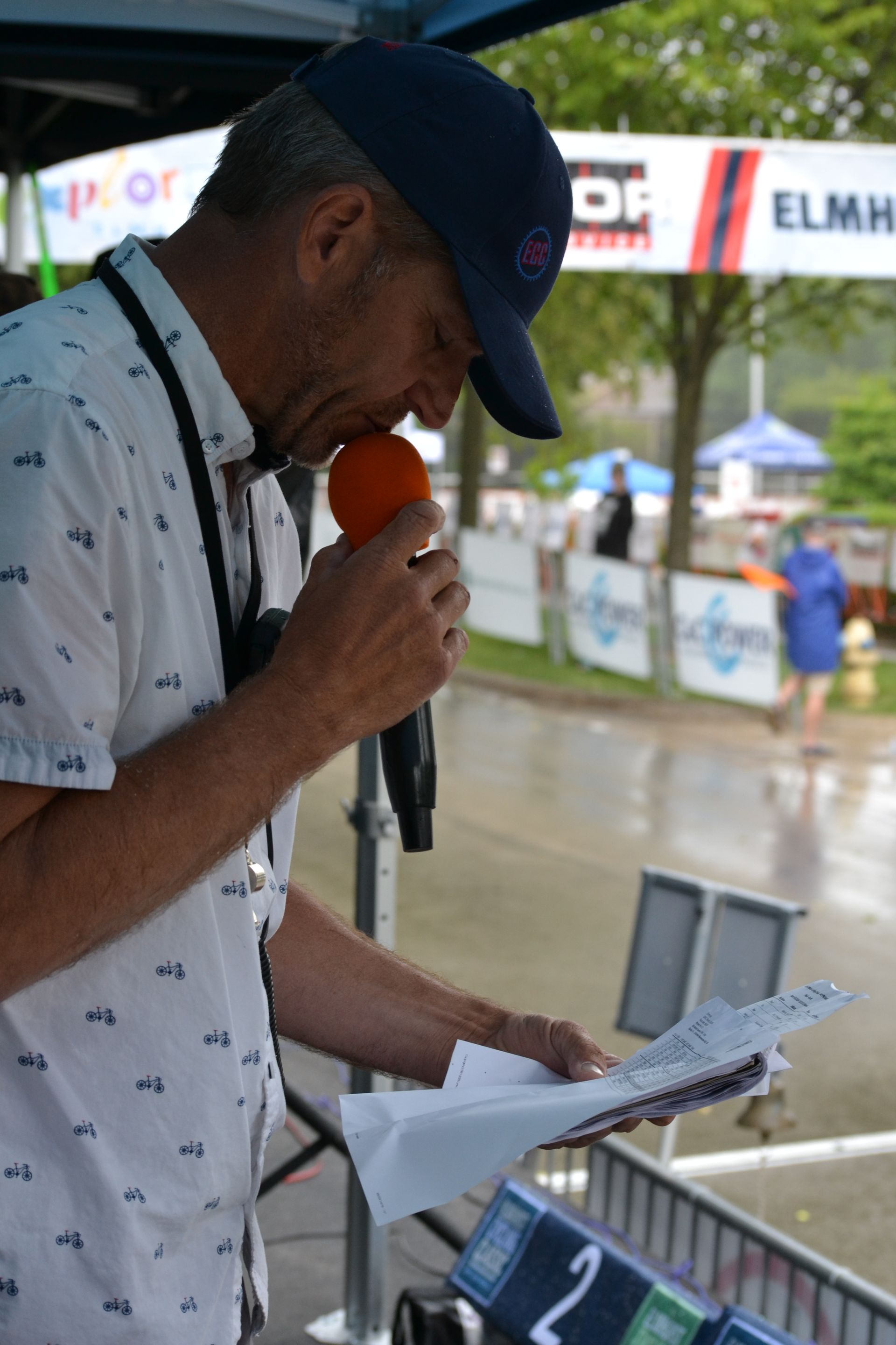 A man is holding a microphone in front of a sign that says df