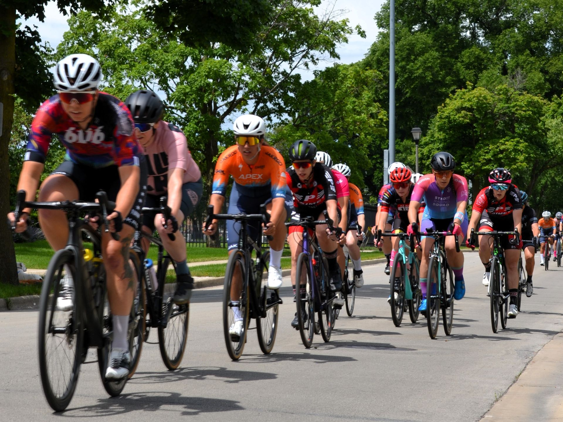 A group of people are riding bicycles down a street.
