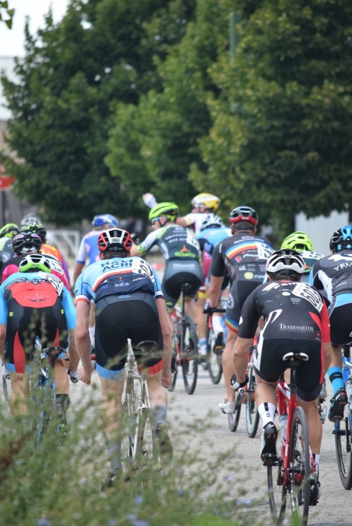 A group of cyclists are riding down a road.