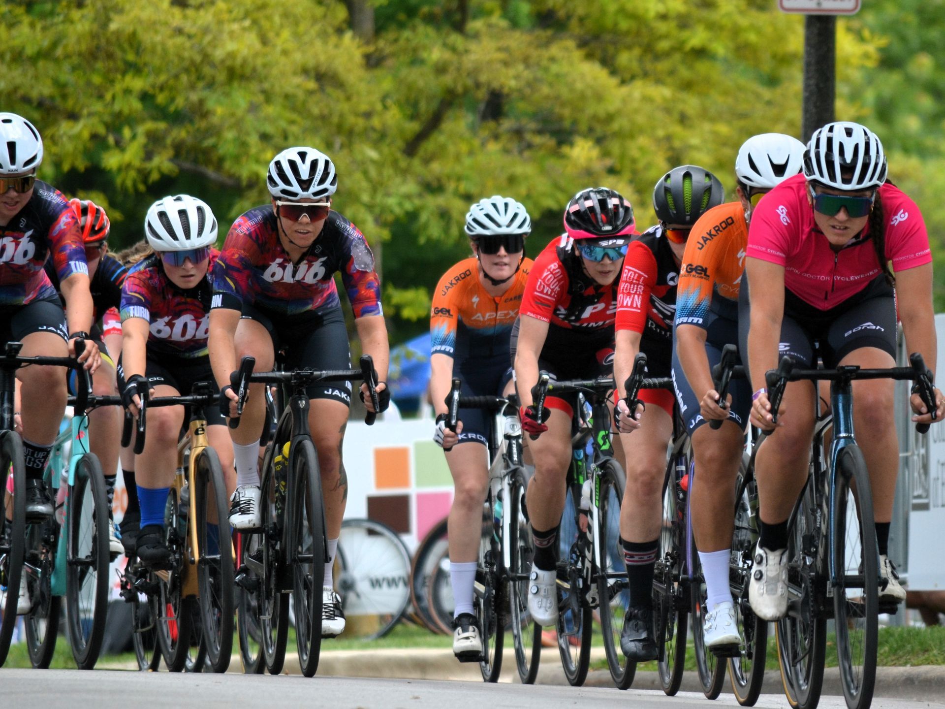 A group of people are riding bicycles down a street.