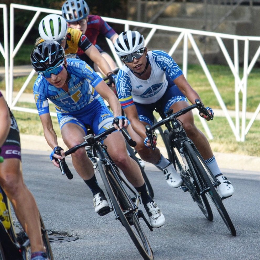 A group of people are riding bicycles down a road