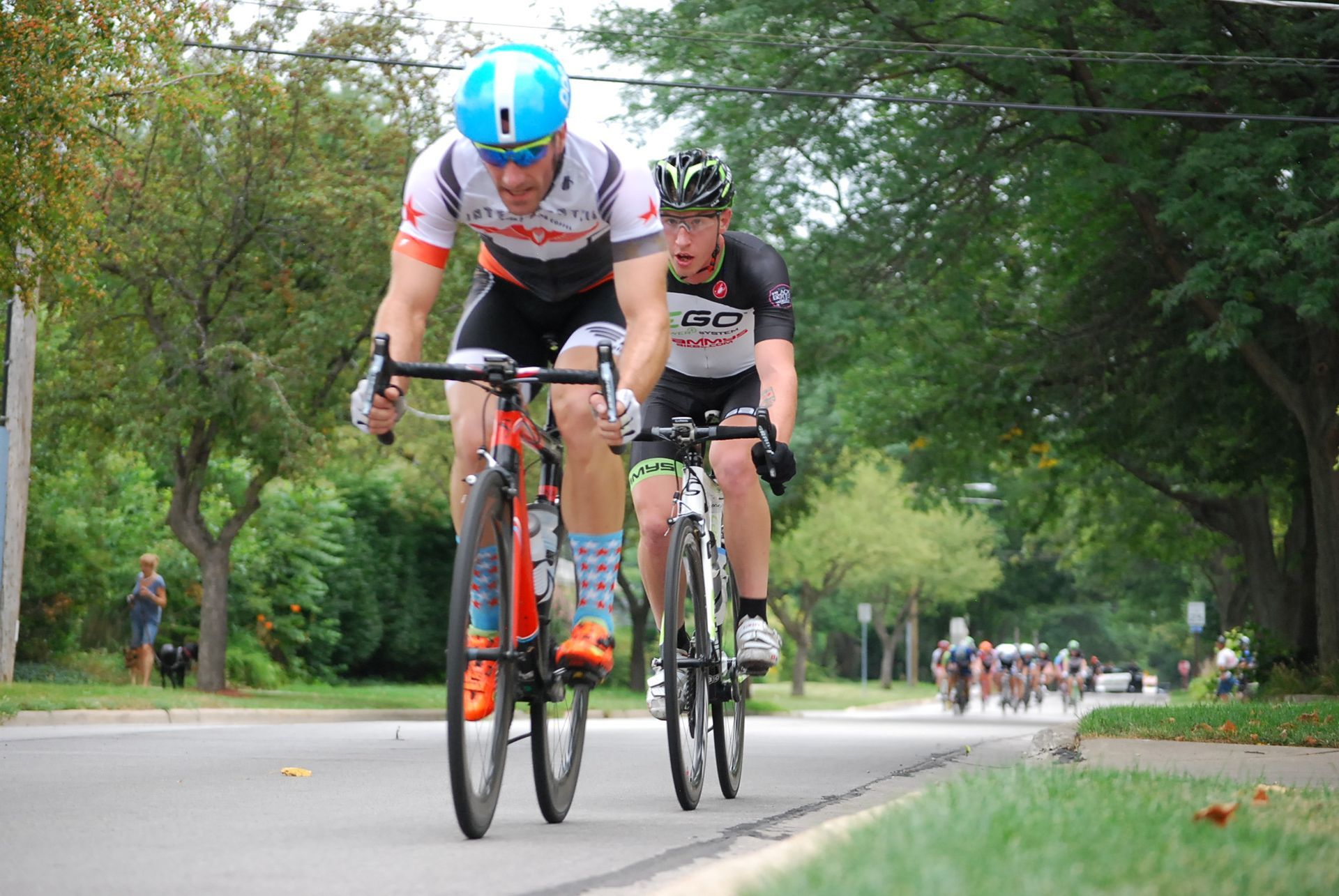 Two men are riding bicycles down a street.