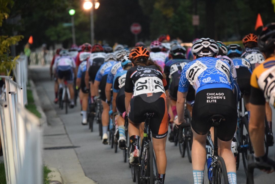 A group of people are riding bicycles down a street.