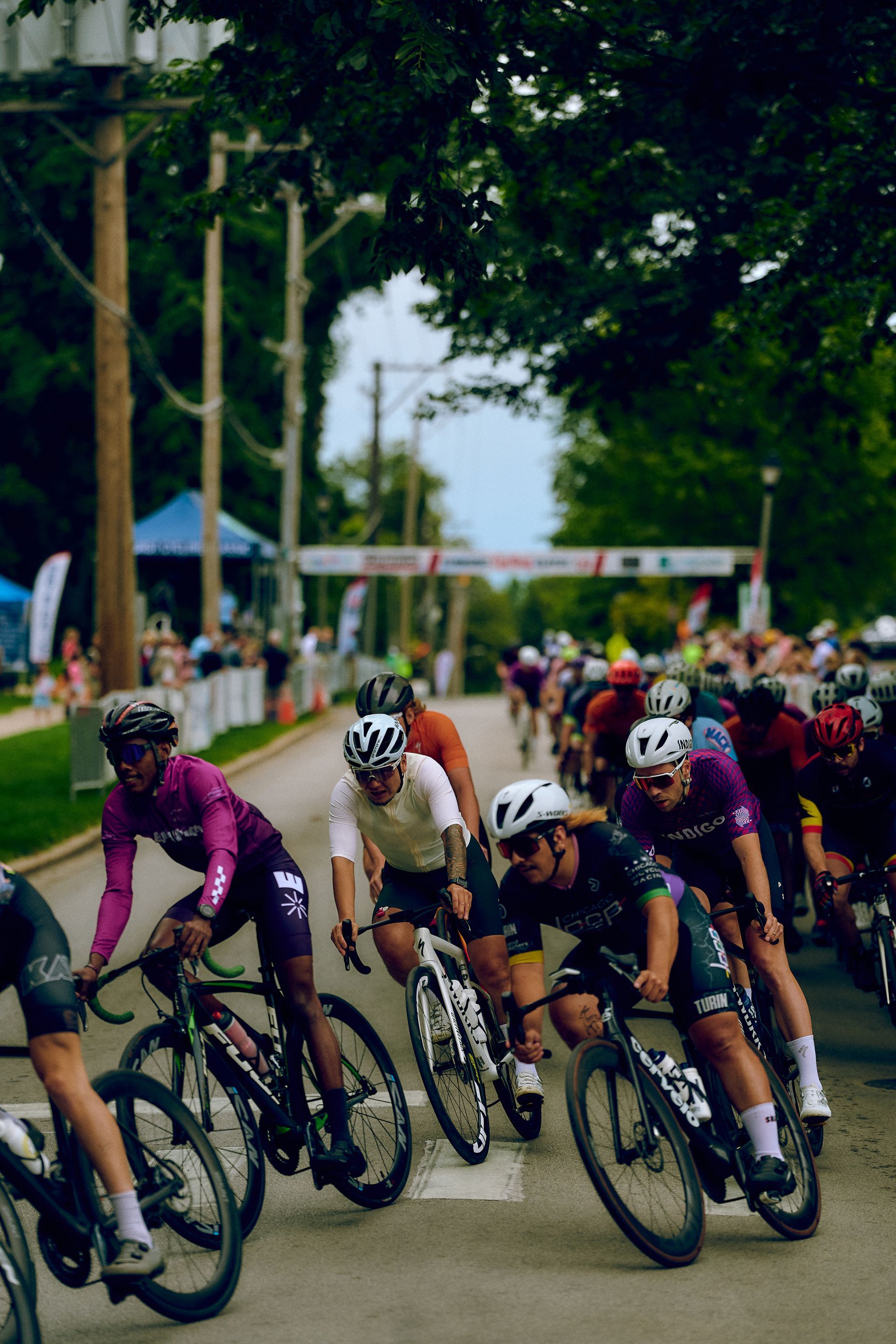 A group of people are riding bicycles down a street.