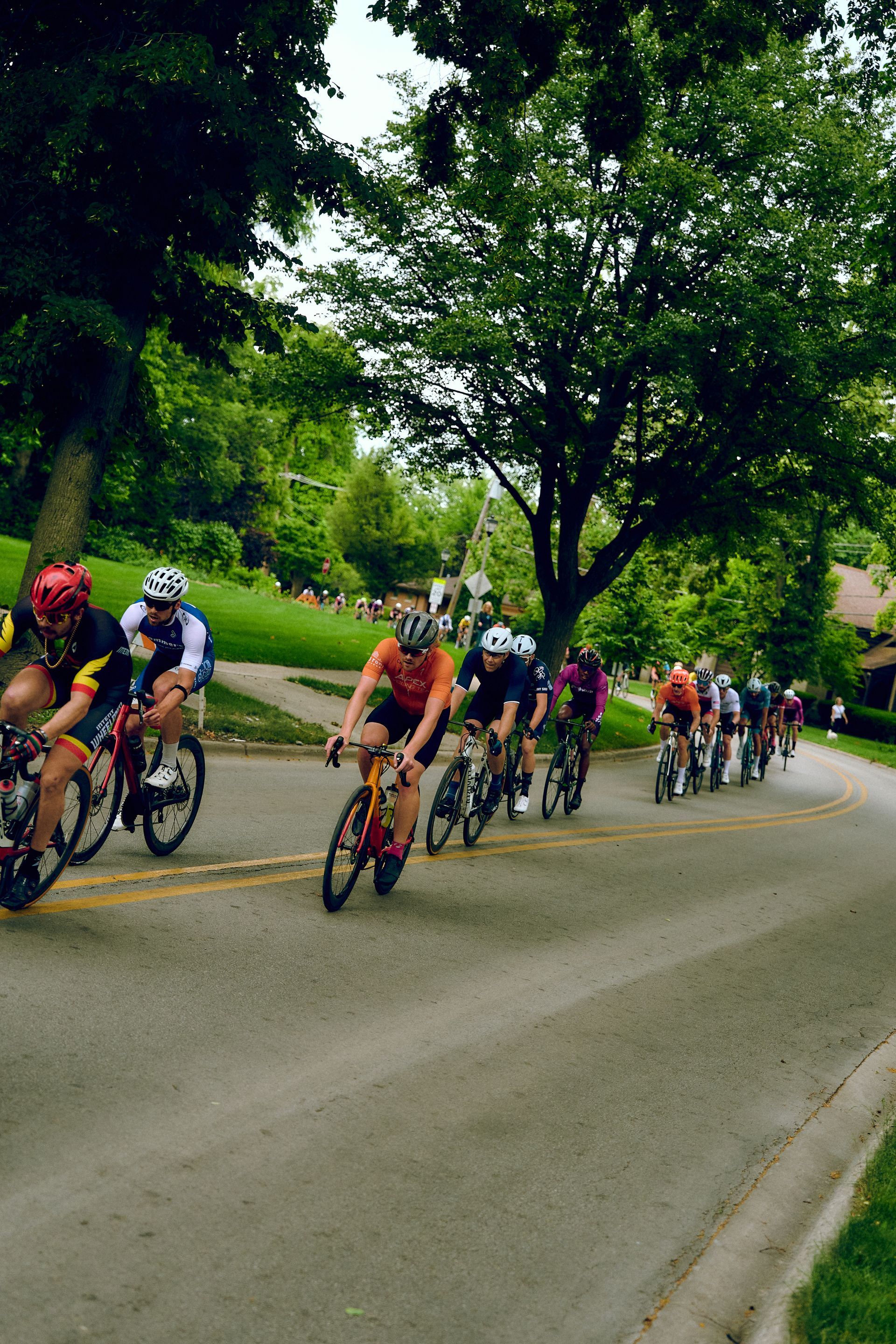 A group of people are riding bicycles down a road