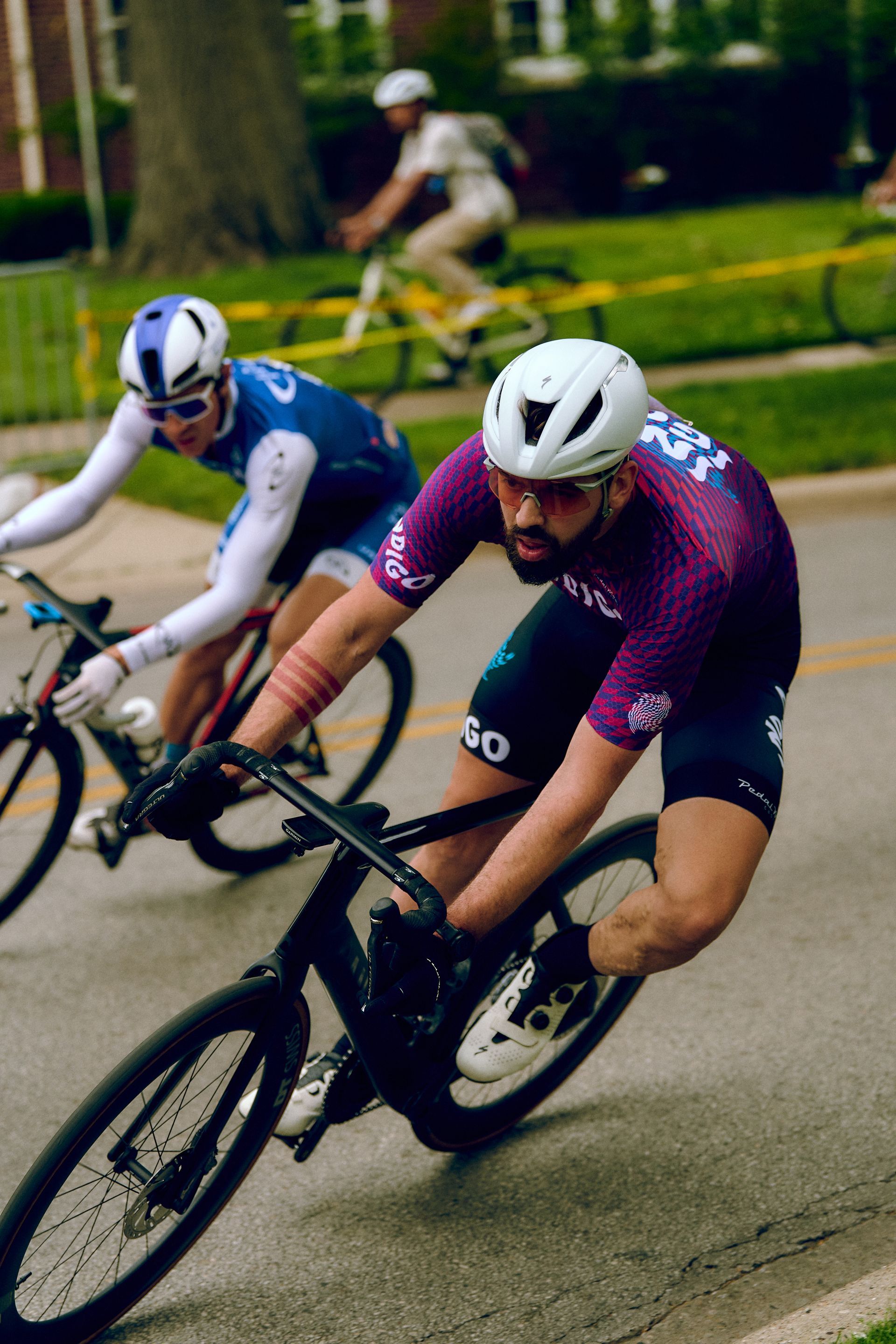 Two men are riding bicycles down a street.