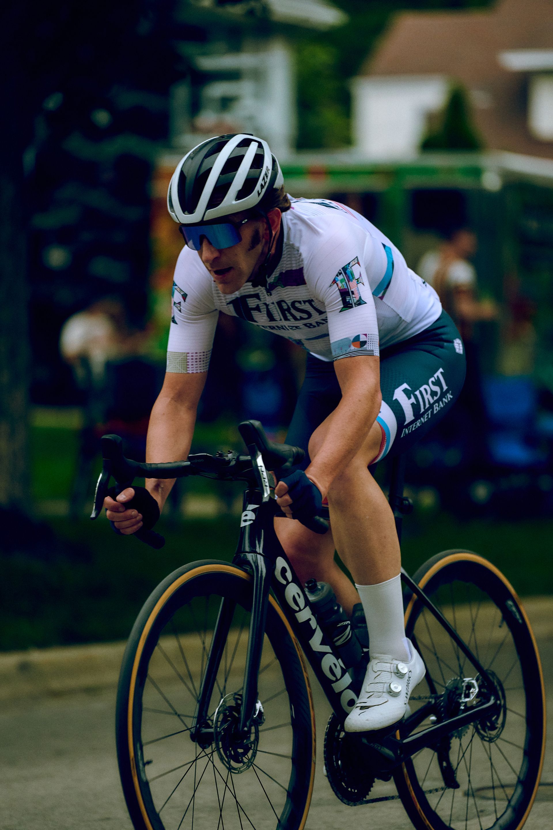 A man wearing a helmet and sunglasses is riding a bicycle.