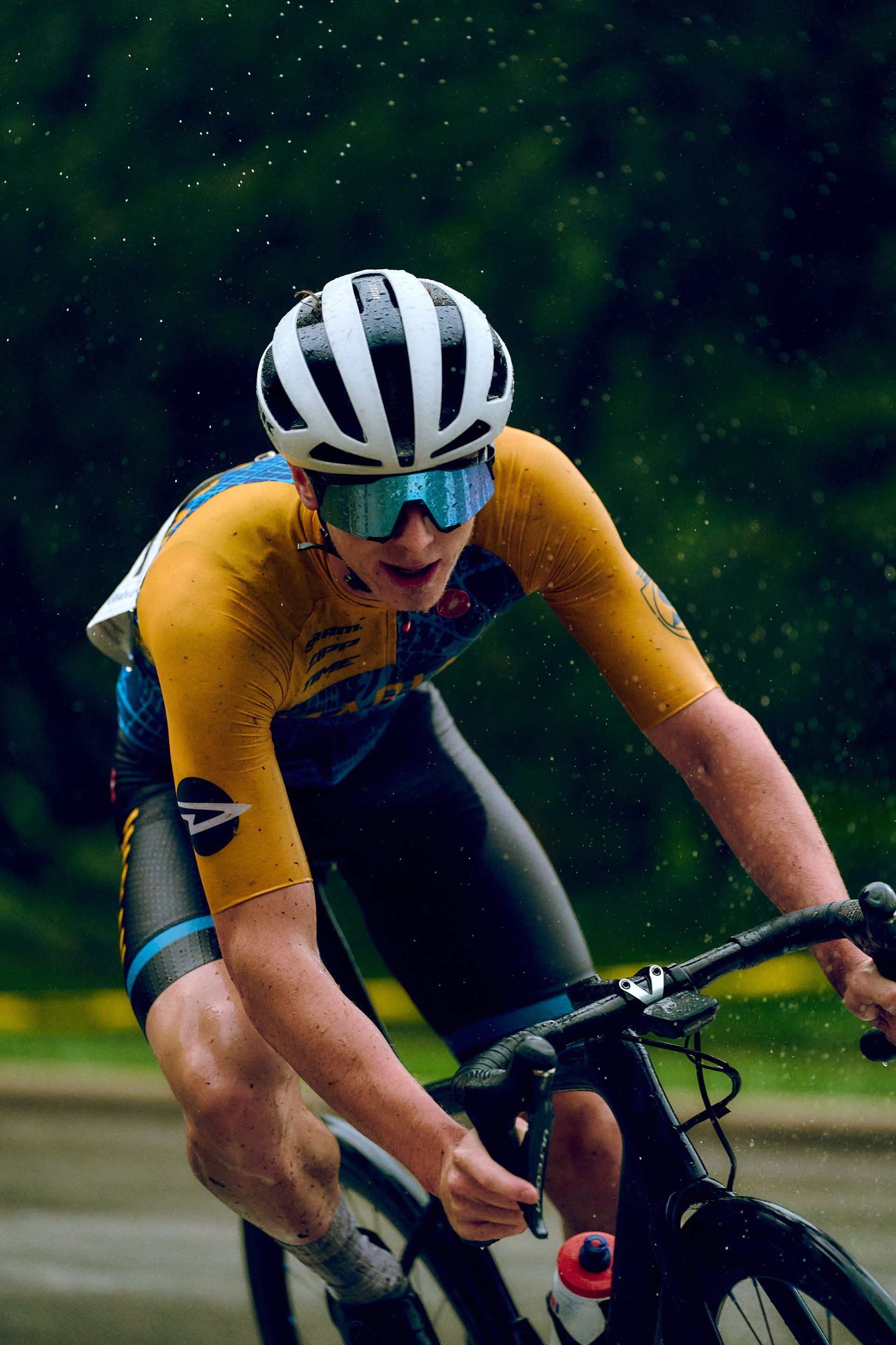 A man wearing a helmet and goggles is riding a bike on a road.