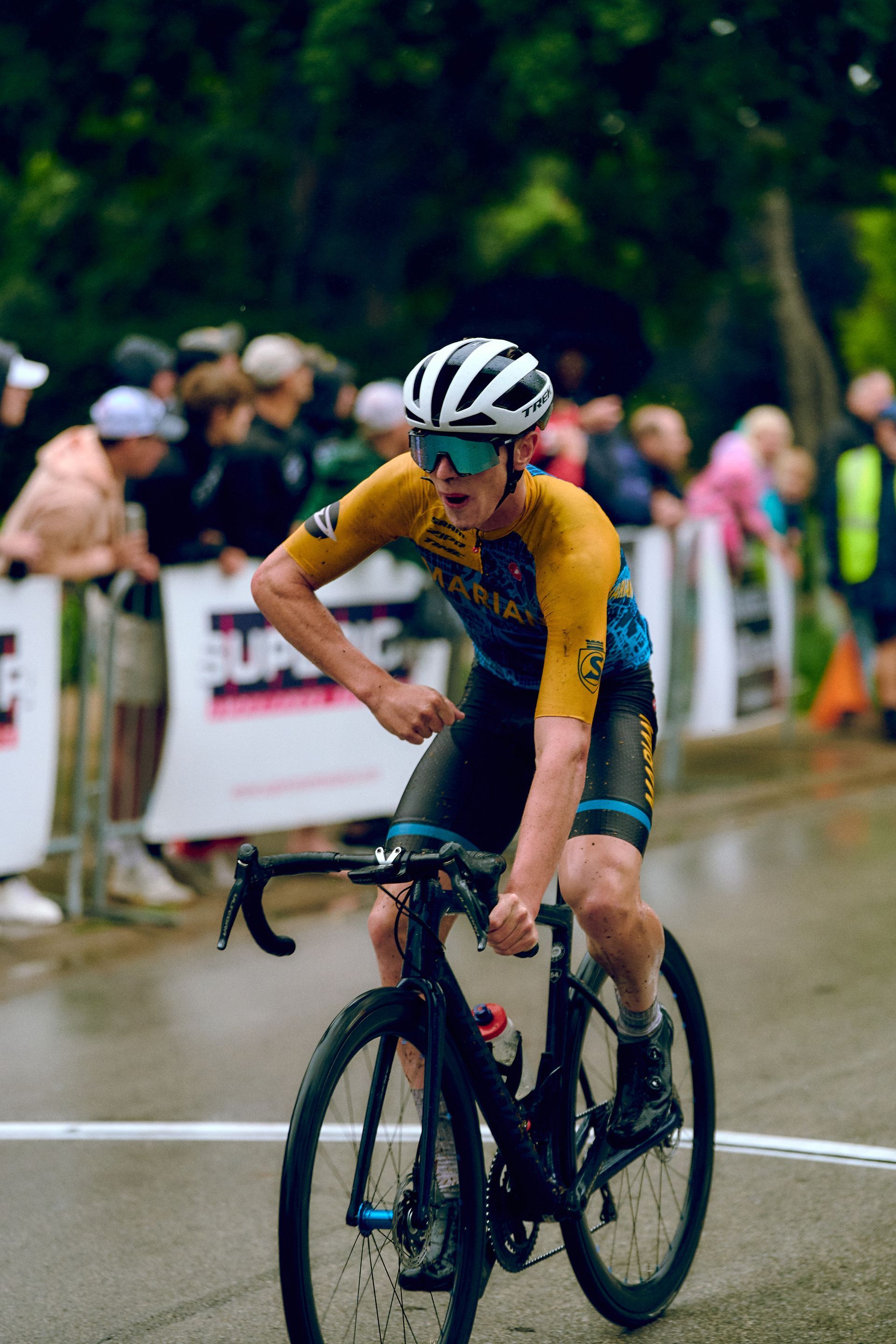 A man is riding a bike on a wet road.