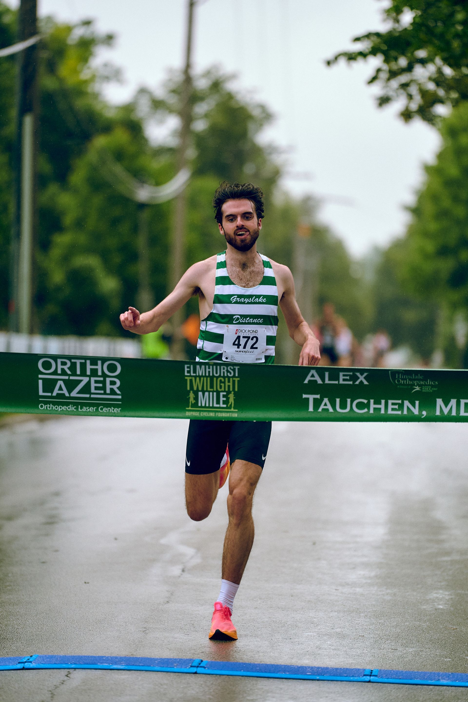 A man is running in a race and crossing the finish line.