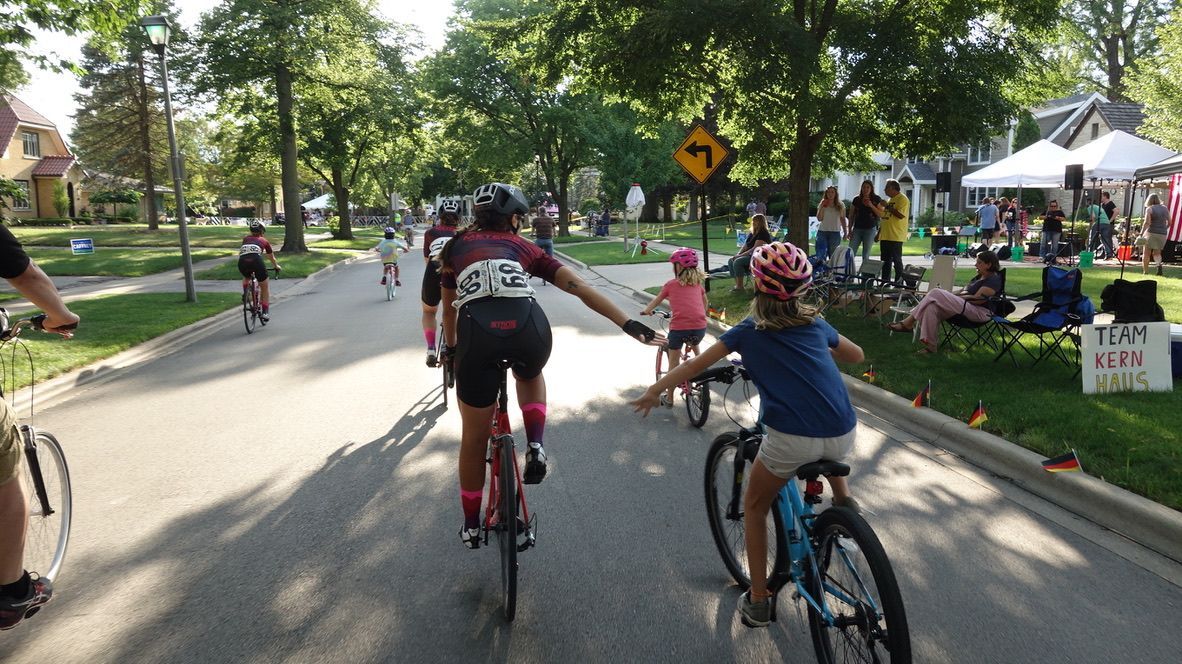 A group of people are riding bicycles down a street.