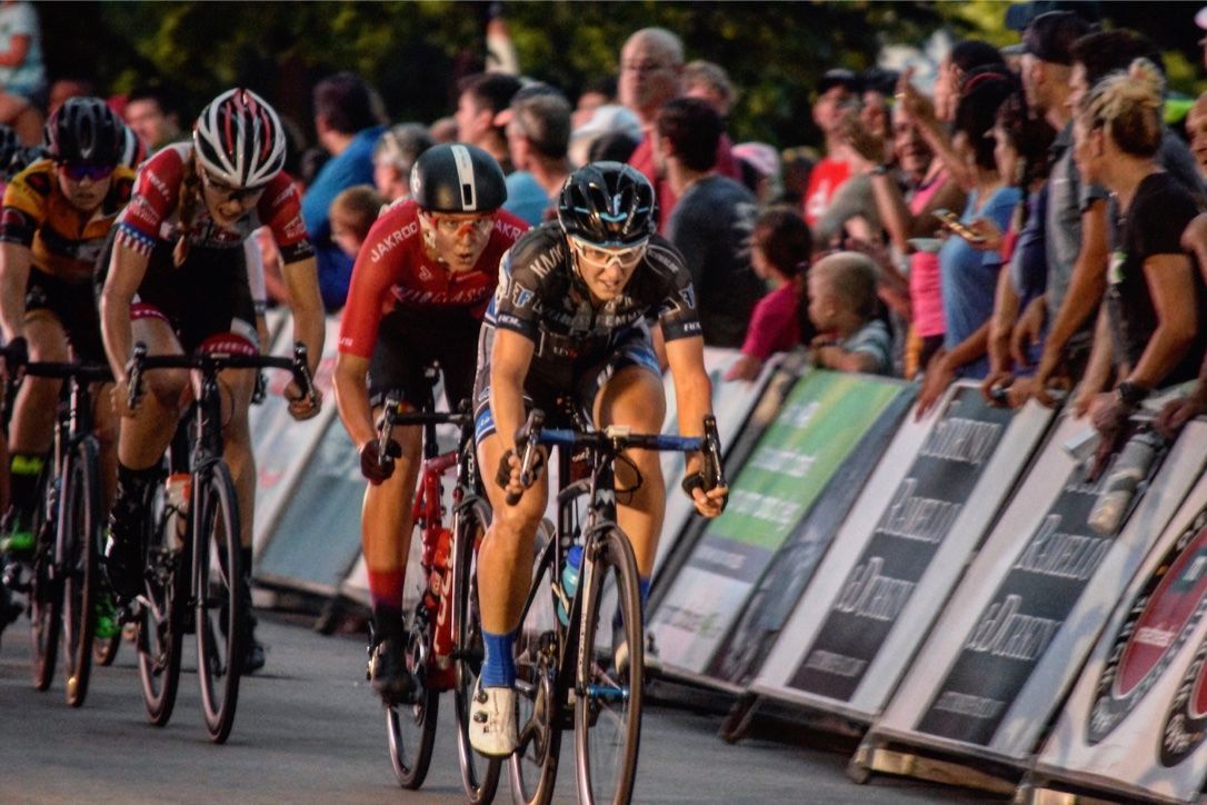 A group of people are riding bicycles down a street.