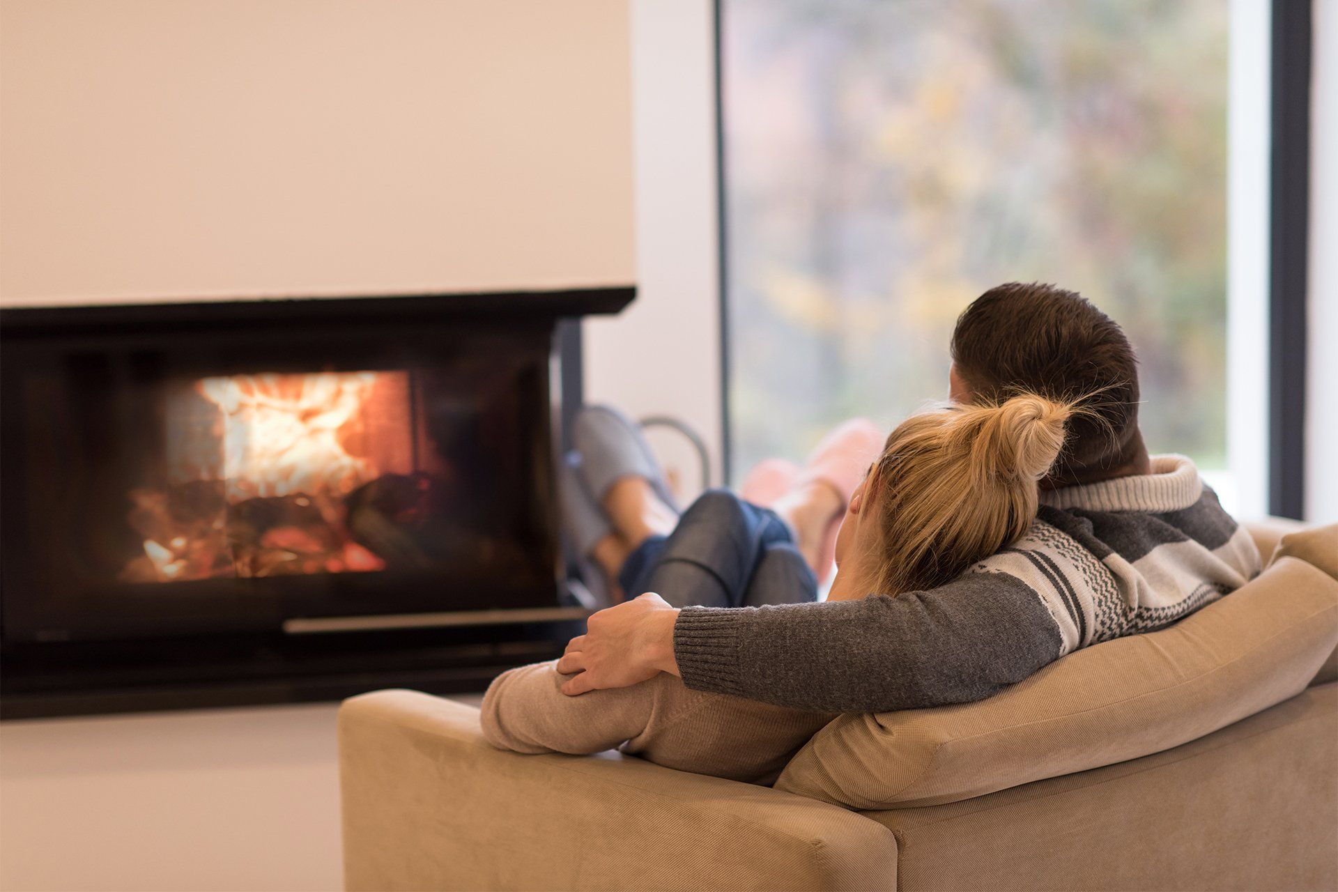 couple sitting in front of a electric fireplace