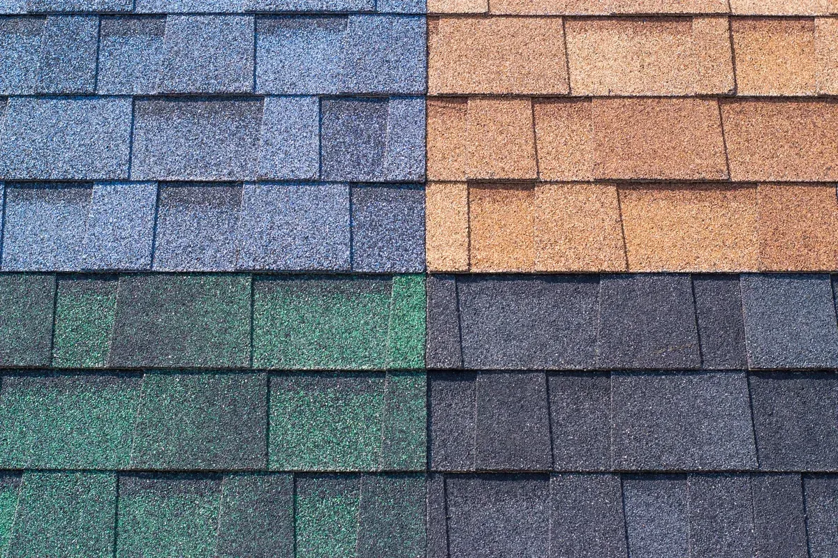 A close up of four different colored shingles on a roof.