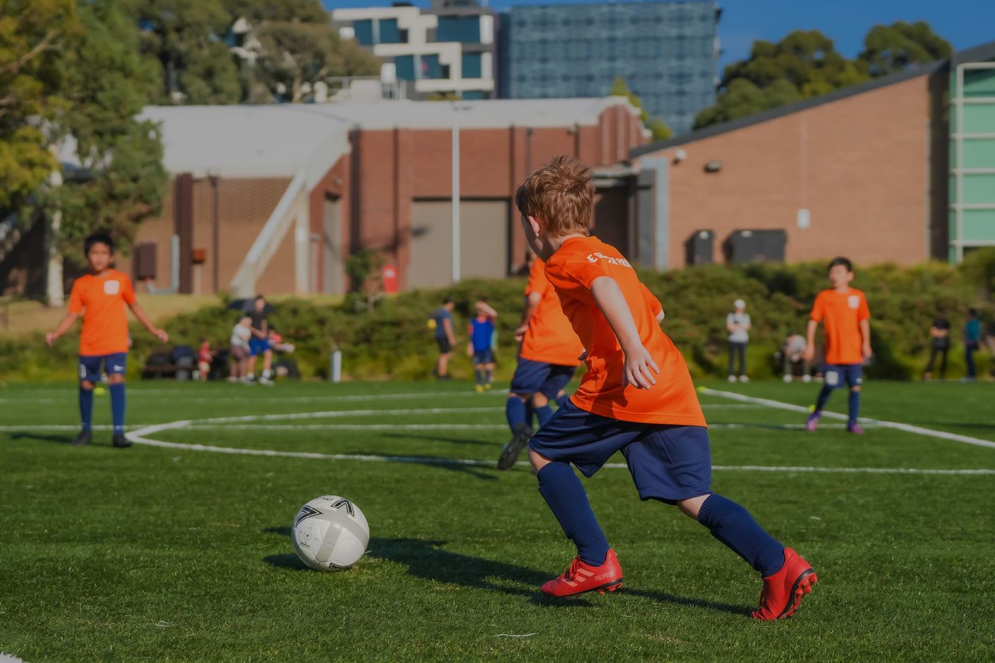 A group of young boys are playing soccer on a field.