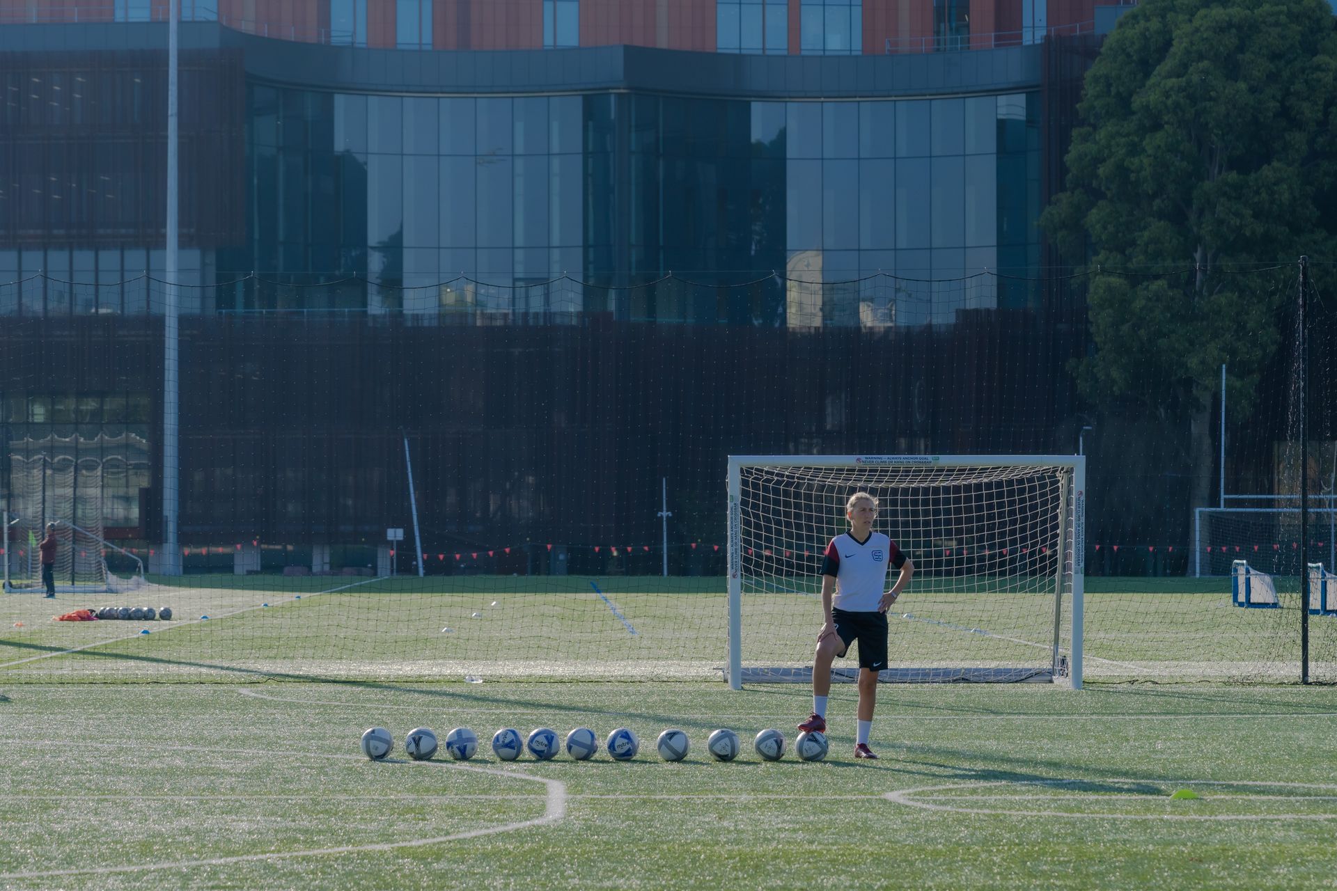 A man is standing in front of a goal on a soccer field.