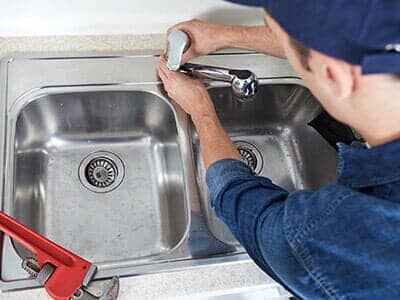 Plumber Adjusting Faucet — Plumbing Service in Dayton, OH